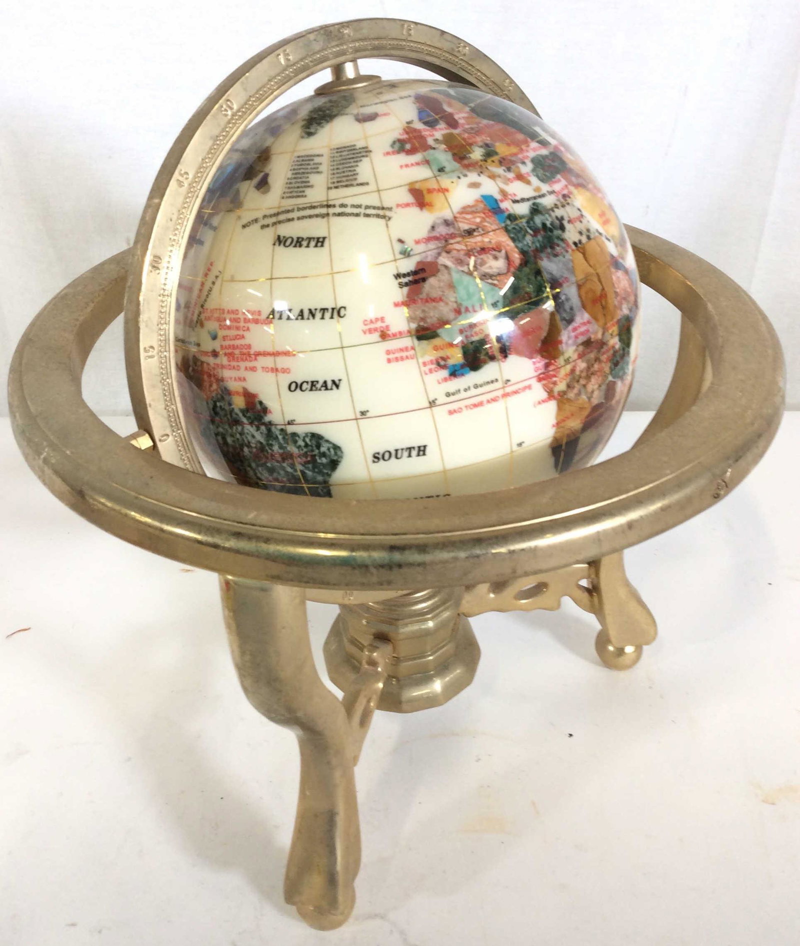 Desktop World Globe in Brass Stand: Attractive Contemporary Globe, composite with simulate stone representing countries. abalone shell. 360 degree movement, longitude latitude line on Globe compass sits under Globe. Ht 10 in. Diameter 1