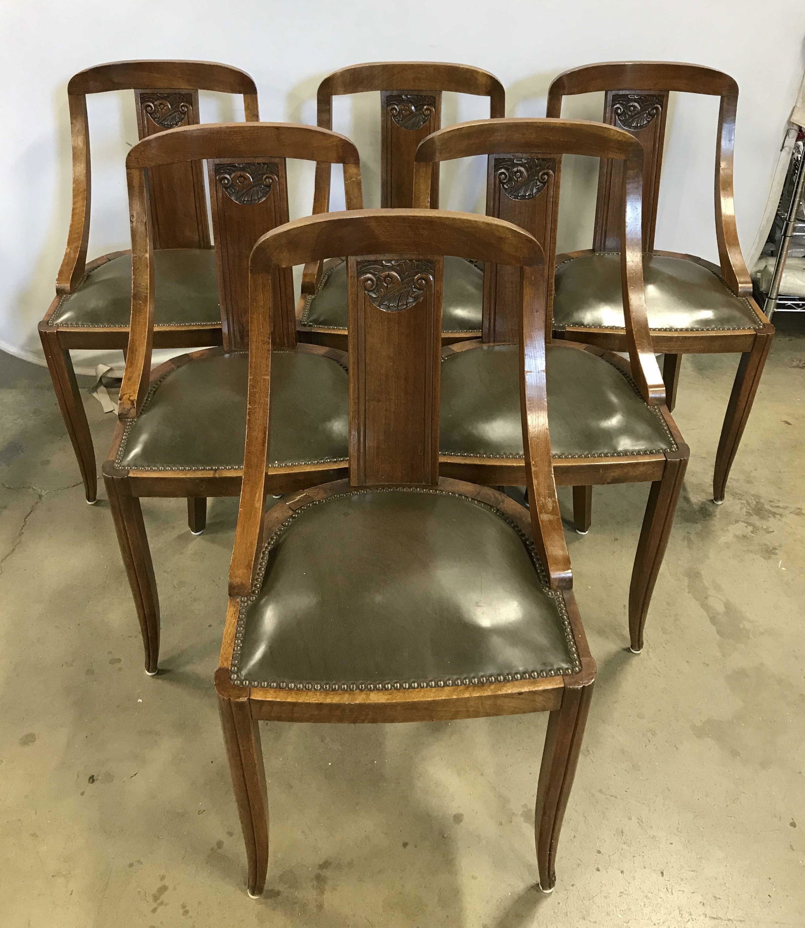 Set 6 Vintage Dining Room Chairs: Set 6 chairs, possibly antique. Carved wood backs and legs. Leather seats secured to frame with brass rivets. Metal feet affixed to each leg. Each piece measures approximately 34 inches H, 18 inches W