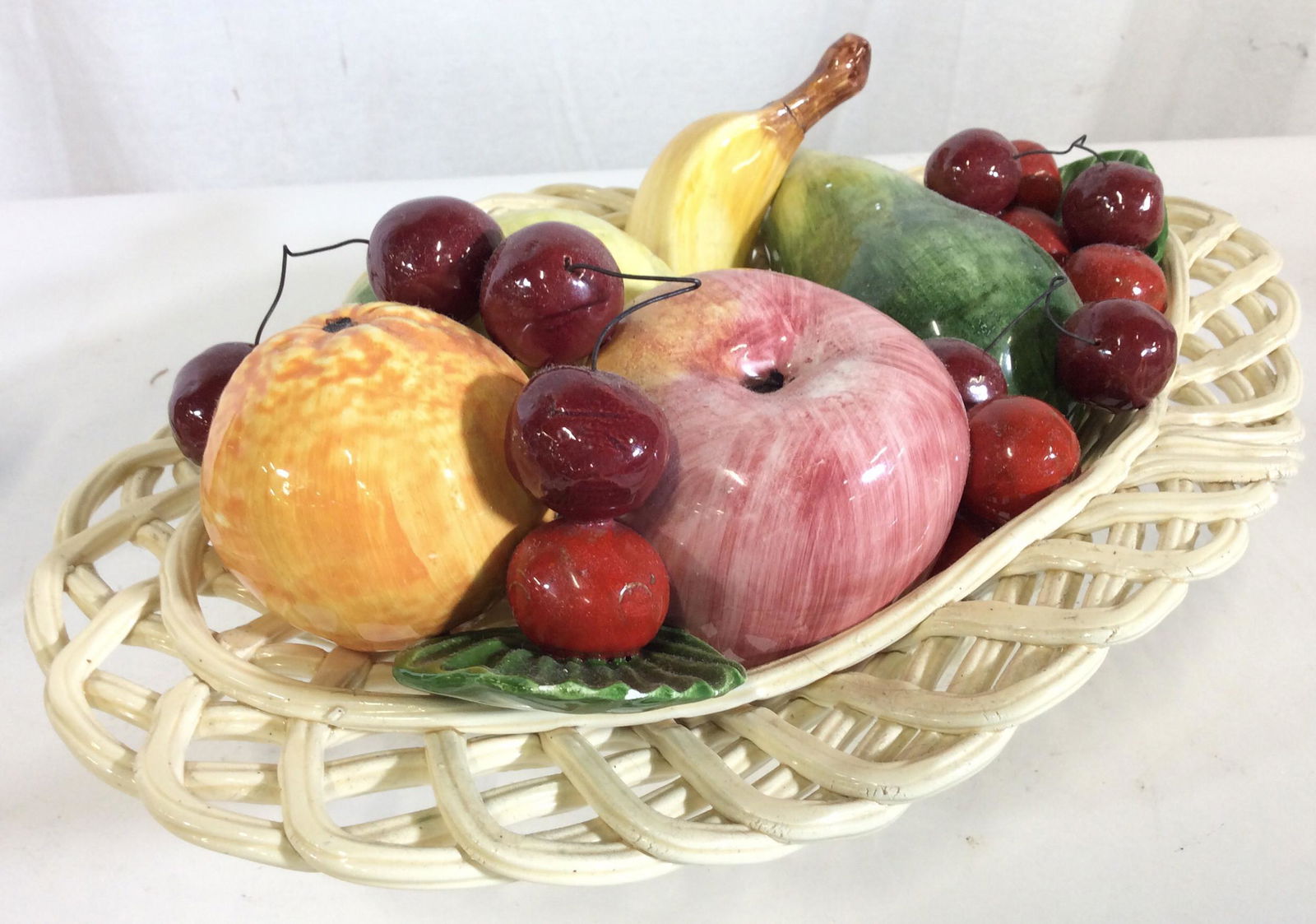 Porcelain BASSANO Centerpiece, Fruit Basket Italy: Handmade Ceramics by Italian craftsmen, Hand Painted. Capodimonte Style. Dated mid 70s. Collection of fruits connected to one another and stationary in basket- banana, cherries, apple , lemon. Openwor