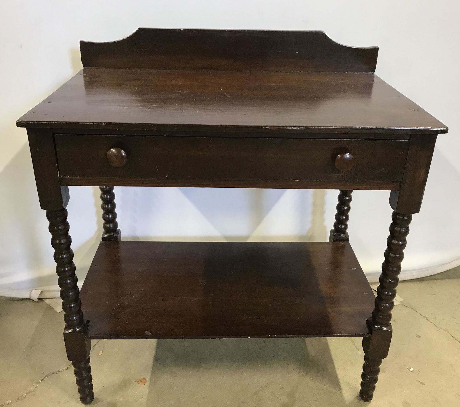 Vintage Wood Wash Table: Vintage, possible antique wash table. One drawer, and bottom shelf, legs are turned. Measures approx 32.5 inches H, 30.25 inches W, and 18.5 inches deep. Wear is consistent with age and use. Decorativ