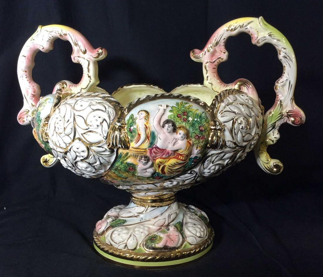 Vntg European Bowl-Urn Centerpiece, Capodimonte: Capodimonte Possibly antique. Large Centerpiece vintage porcelain Repoussé, Hand Painted, Gilted Rope Design rim, embellished High Handles, depicts Adam & Eve In garden. Crack to base appeared Repair