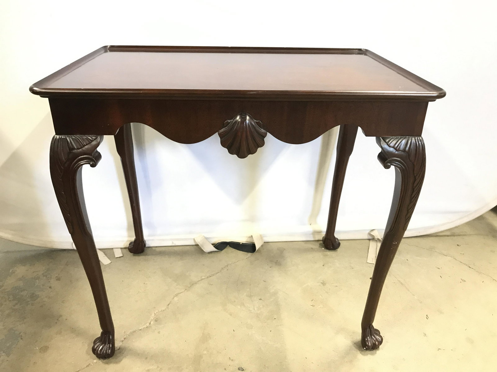 Vintage KINDEL Wood Side Table: Vintage wood side table. Legs are carved, feet are carved to resemble lions paws. Tabletop is concave. Underside reads as KINDEL GRAND RAPIDS. Carved shell detailing can be found on the front and back