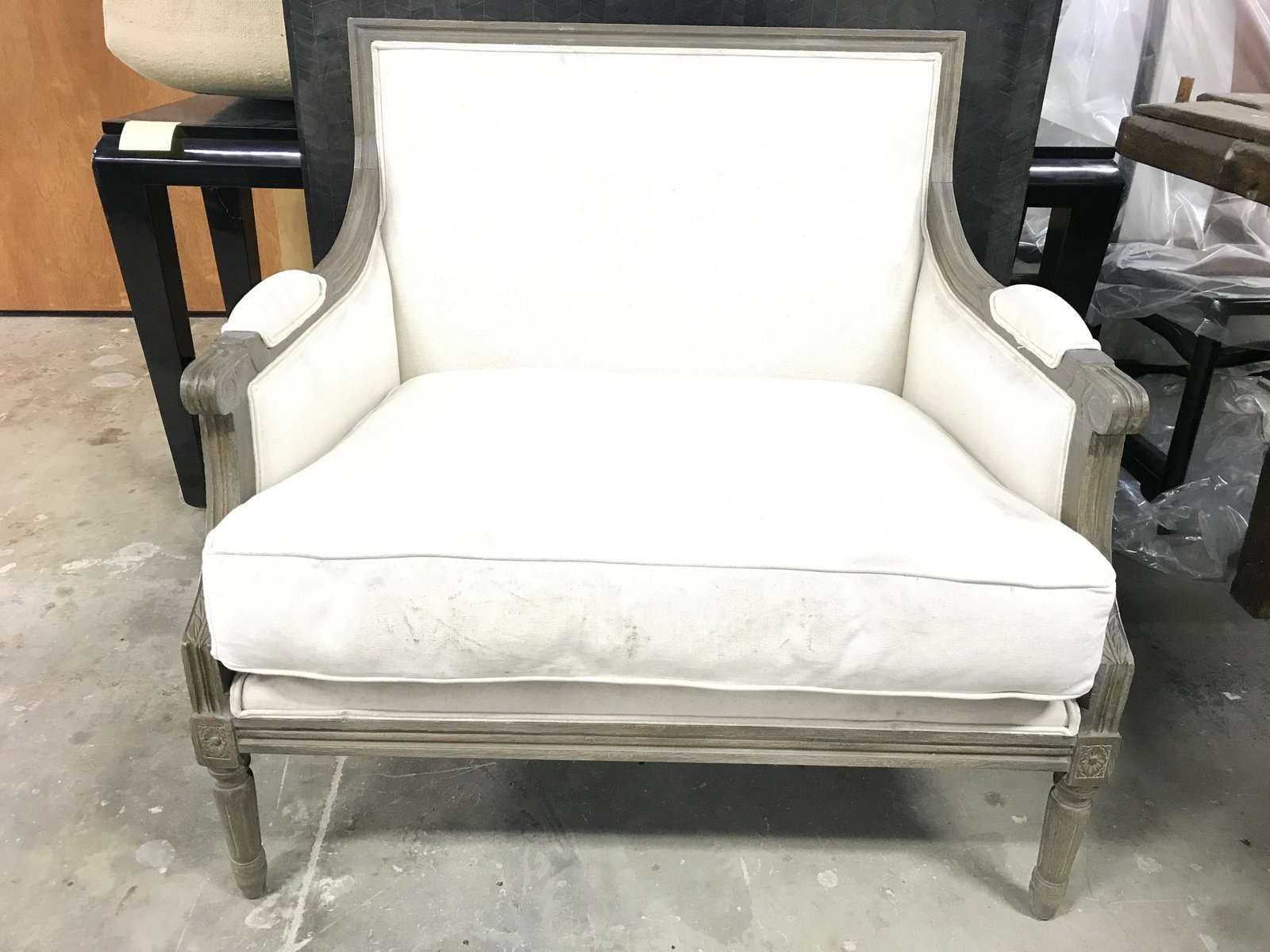 Vintage Cream Toned Upholstered Bergere: Bergere is upholstered with cream toned fabric. Piece has upholstered armrests. Frame is wooden with carved detail. Piece measures approximately 34 inches wide 35 inches tall 28 inches deep. Bergere, 