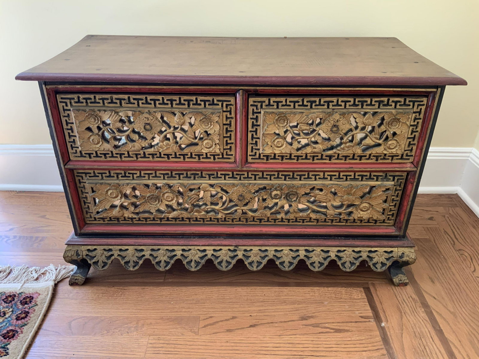 Vintage Asian Red and Gold Leafed Carved Chest: Vintage possibly antique Asian piece, ornately carved three drawer chest, red painted with carved paneling of flowers vines, geometrics all gold leafed, three drawers atop scalloped apron and short sc