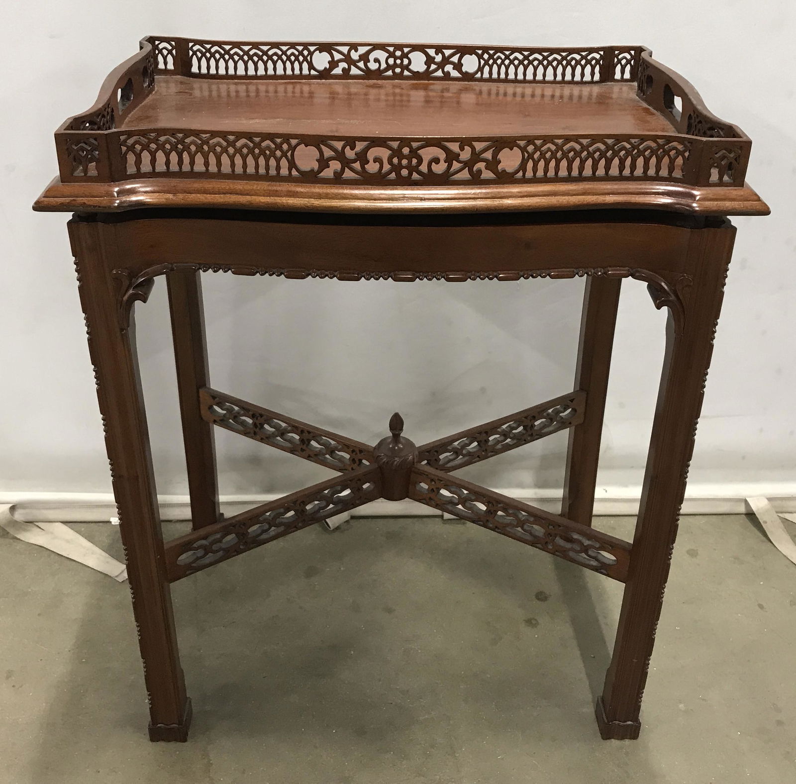 Vintage Side Table W Wood Gallery: Vintage gallery style side table. Table is vintage, possibly antique, constructed from carved wood. An x shaped stretcher joins the legs, a finial is at the center of the stretcher. The table top is r