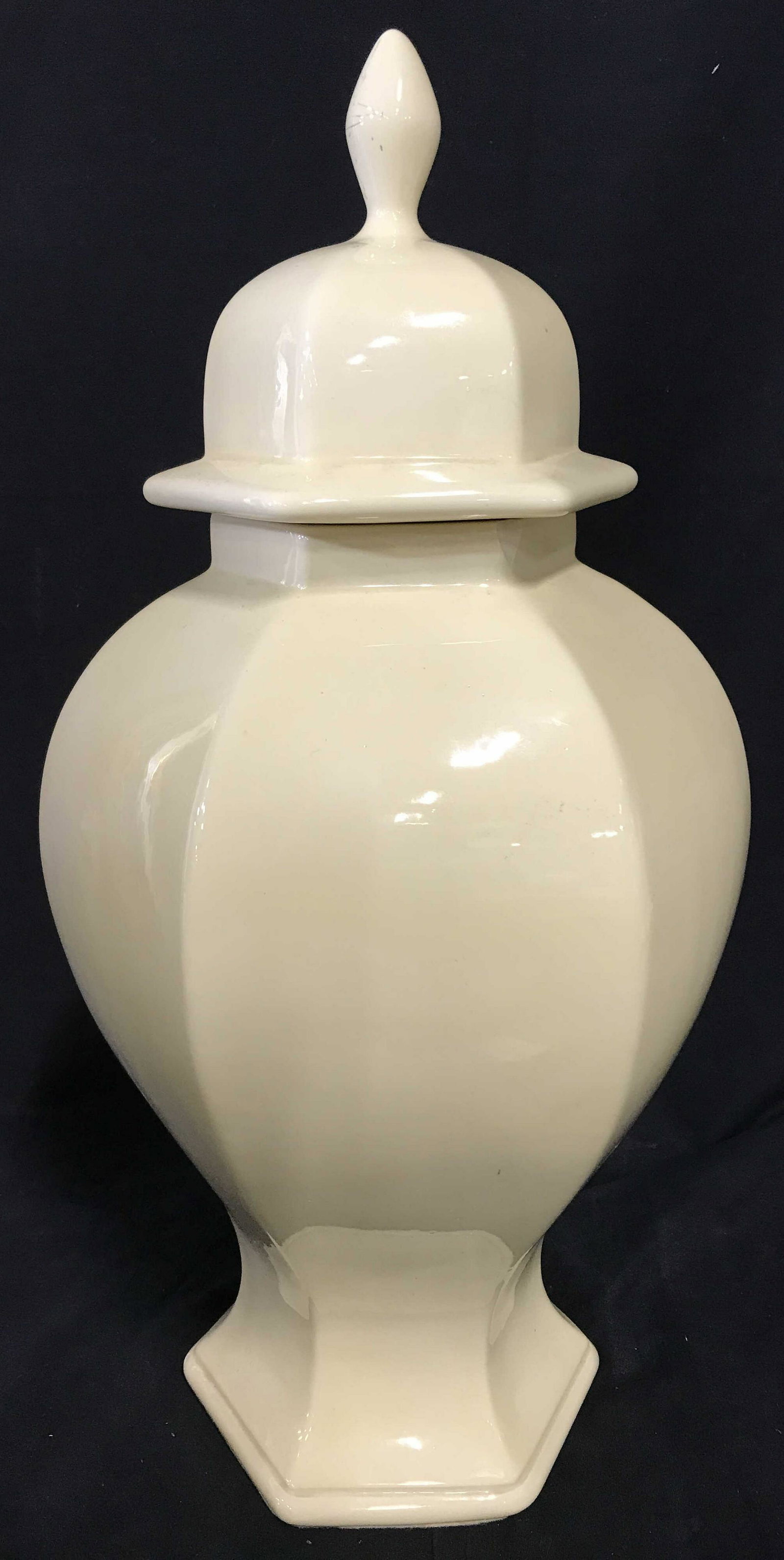 Cream Toned Ceramic Ginger Jar Urn: Cream toned lidded urn. Hexagonal Lid is topped with a finial. Ceramic is glazed, underside of urn is lined with felt. Measures approx 19.75 inches H, and 10.5 inches W. Wear is consistent with age, s