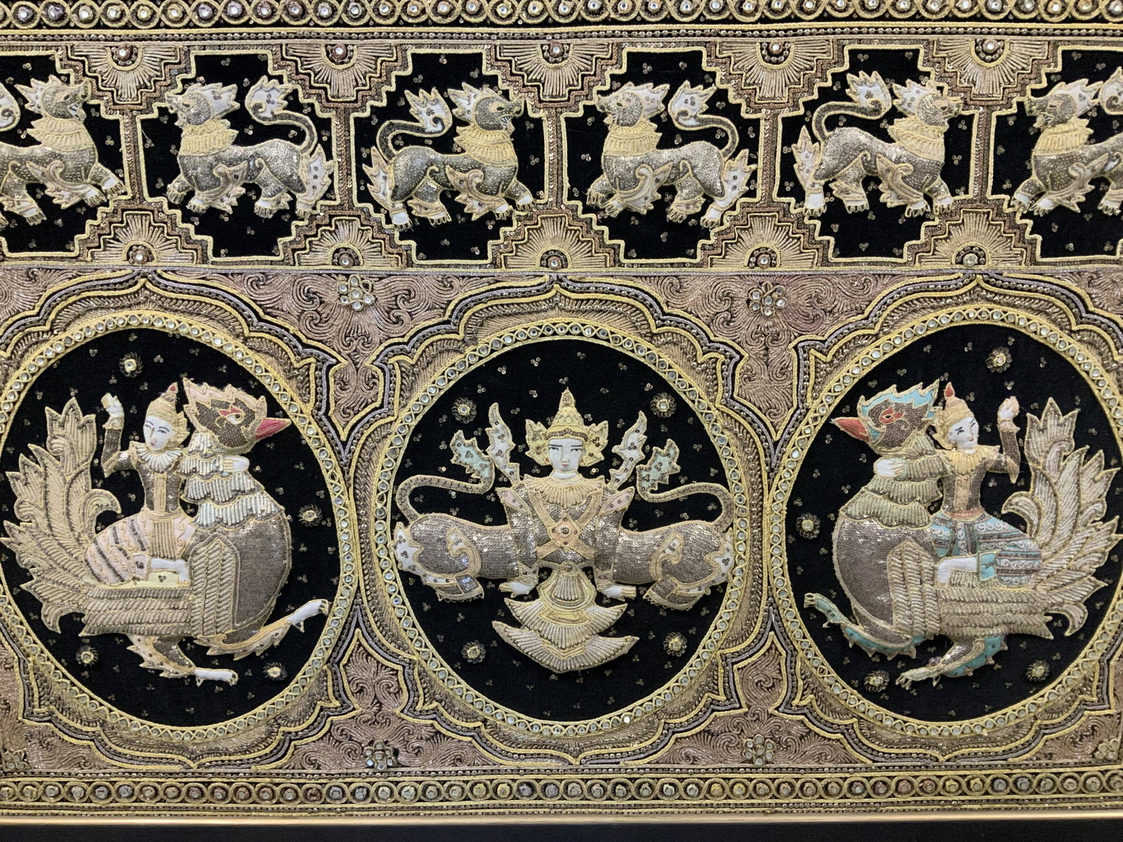 Framed Embroidered Far Eastern Motif Tapestry: Framed embroidered tapestry, possibly Indonesian, no apparent signatures or inscriptions, not examined out of frame, feline creatures and figures riding chickens, measures 43 7/8 x 61 1/2 inches, wood