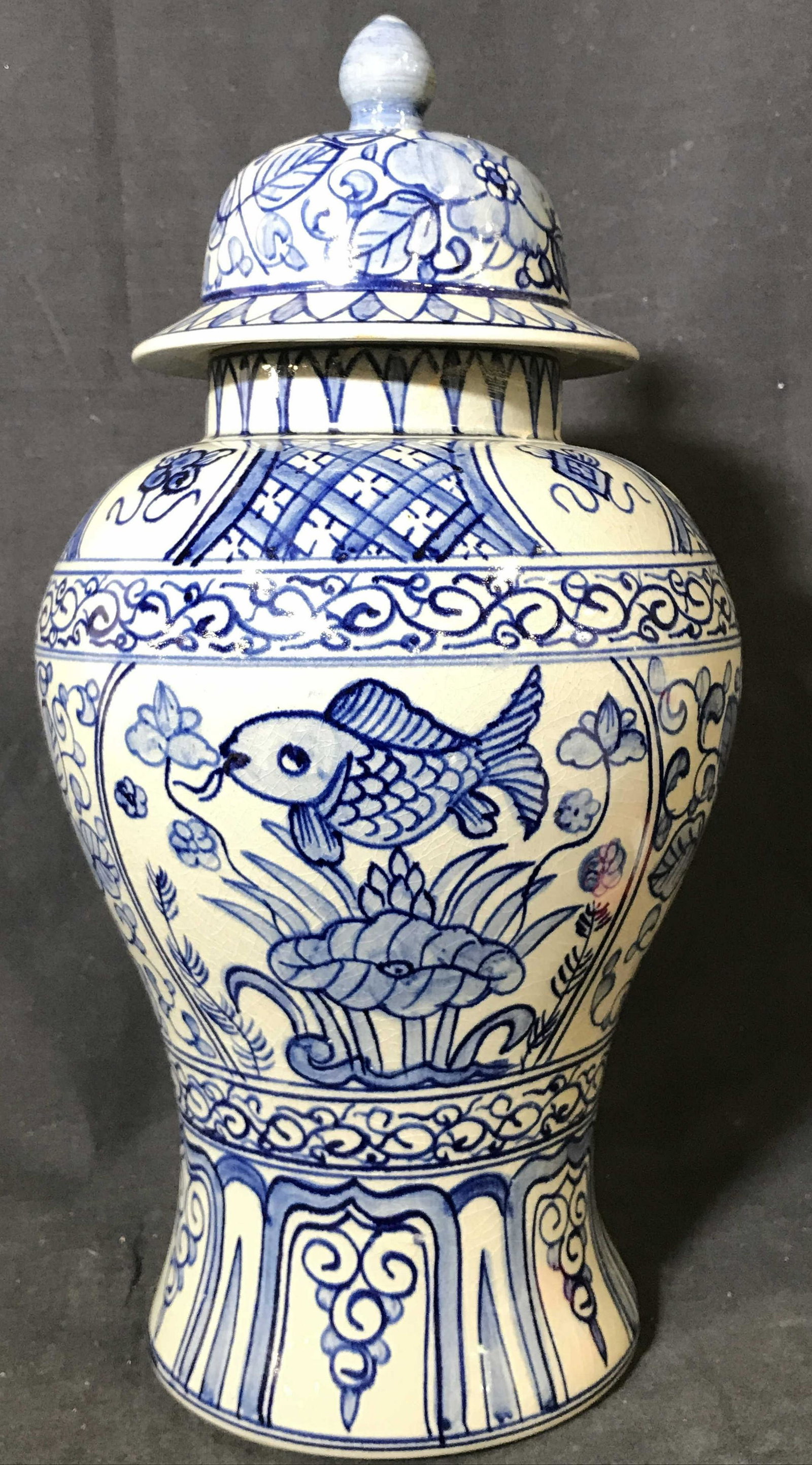 Vintage Signed Chinoiserie Ceramic Ginger Jar: Ginger jar appears to be ceramic possibly porcelain. Piece is slate toned with blue toned floral, leaf, fish & geometric detail. Ginger jar Has lid. Piece measures approximately 16 inches tall 8 inche