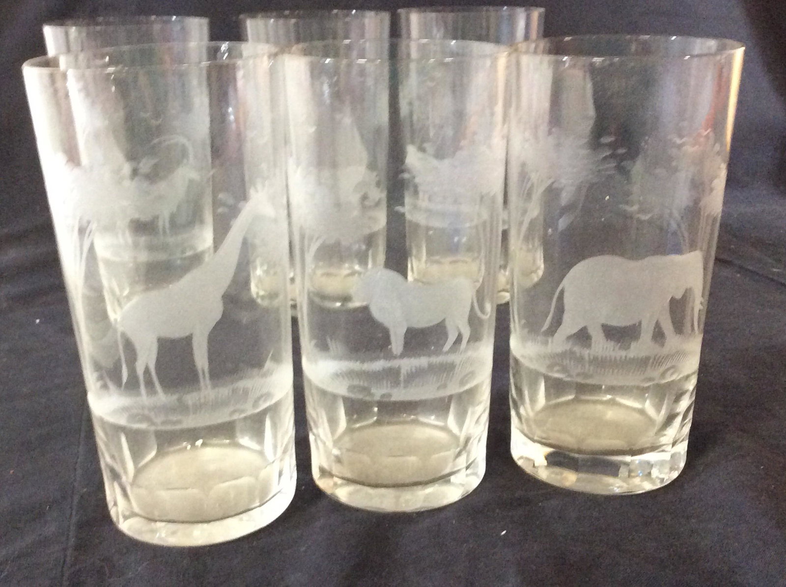 Etched African Wildlife Crystal Glasses, Africa: Vintage glasses bought in Africa, for cocktails, Water, Juice, more. Each glass has a different animal- Elephant, Giraffe, Lion, rhino, more. 5 3/8 in ht. 2 5/8 in diameter. Property of New Cannan, CT