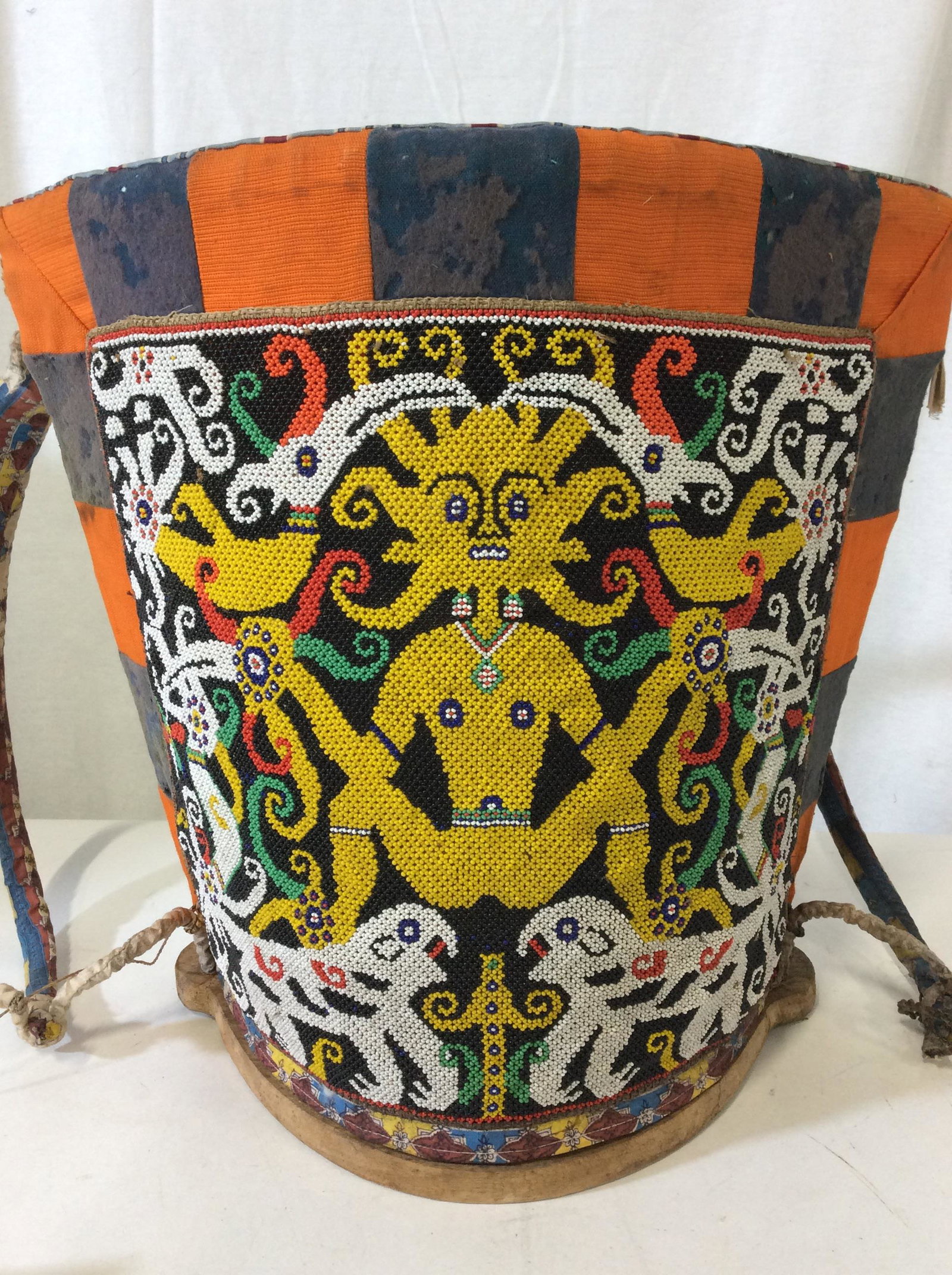 Borneo DAYAK Hand Crafted Child Carrier, Indonesia: A beautiful Borneo child carrier, decorated with Hornbill, Aso/Serpent/ Dragon & terabai, made from beads on fabric covering a woven basket. Many stains to fabric consistent with age, use and exposure