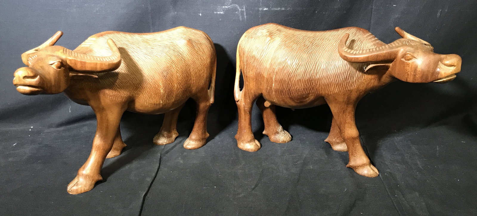 Pair Hand Carved Wooden Oxen: Pair of hand carved wooden oxen, no apparent signatures or stamps, one is a female the other a male otherwise completely identical, female ox has crack to left horn, both measure approximately 10.5 in