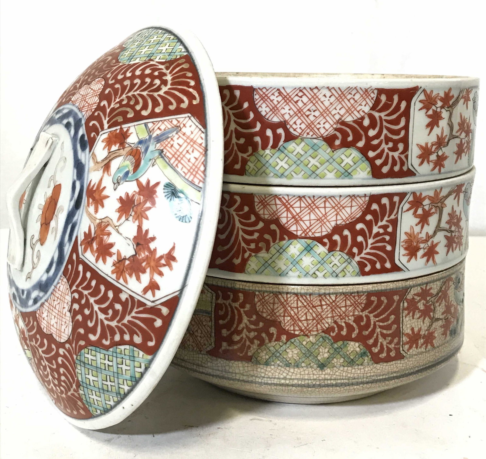 Antique Asian Porcelain Stacked Tiffin Bento Box: Tiffin box contains 3 tiers. Each are porcelain and appear to be hand painted with intricate floral, leaf, geometric & bird detail. Base has painted ring detail on underside. Tiffin box appears to be 