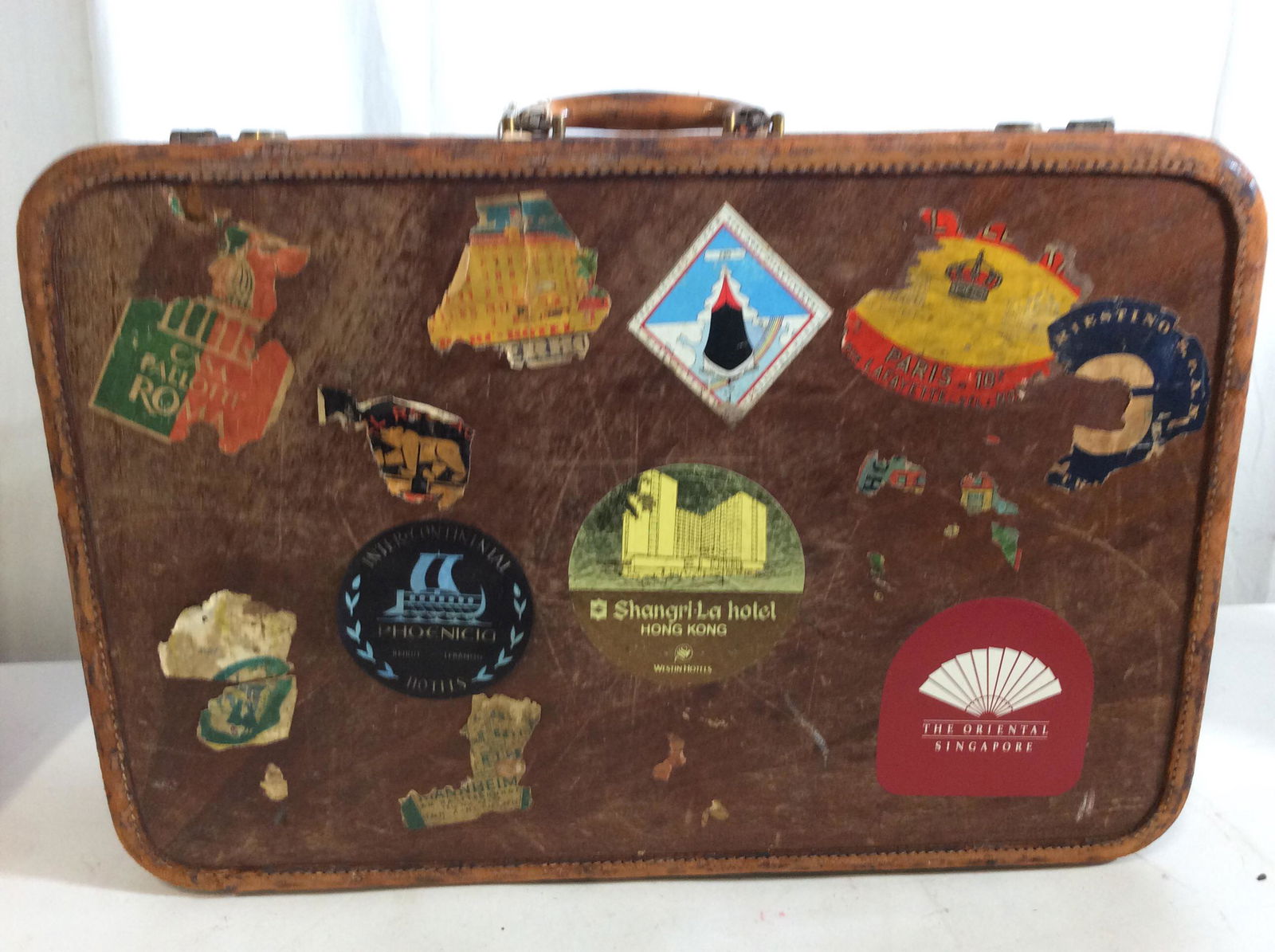 Vintage World Traveler Amelia FARHART Suitcase: Suitcase dates back to 1960s. Hard case wood with myriad hotel stickers from around the world. Suitcase does not open, no key. Brass YALE lock system. Measures 21 x 7 in. Ht. 14.5 in. Very worn materi