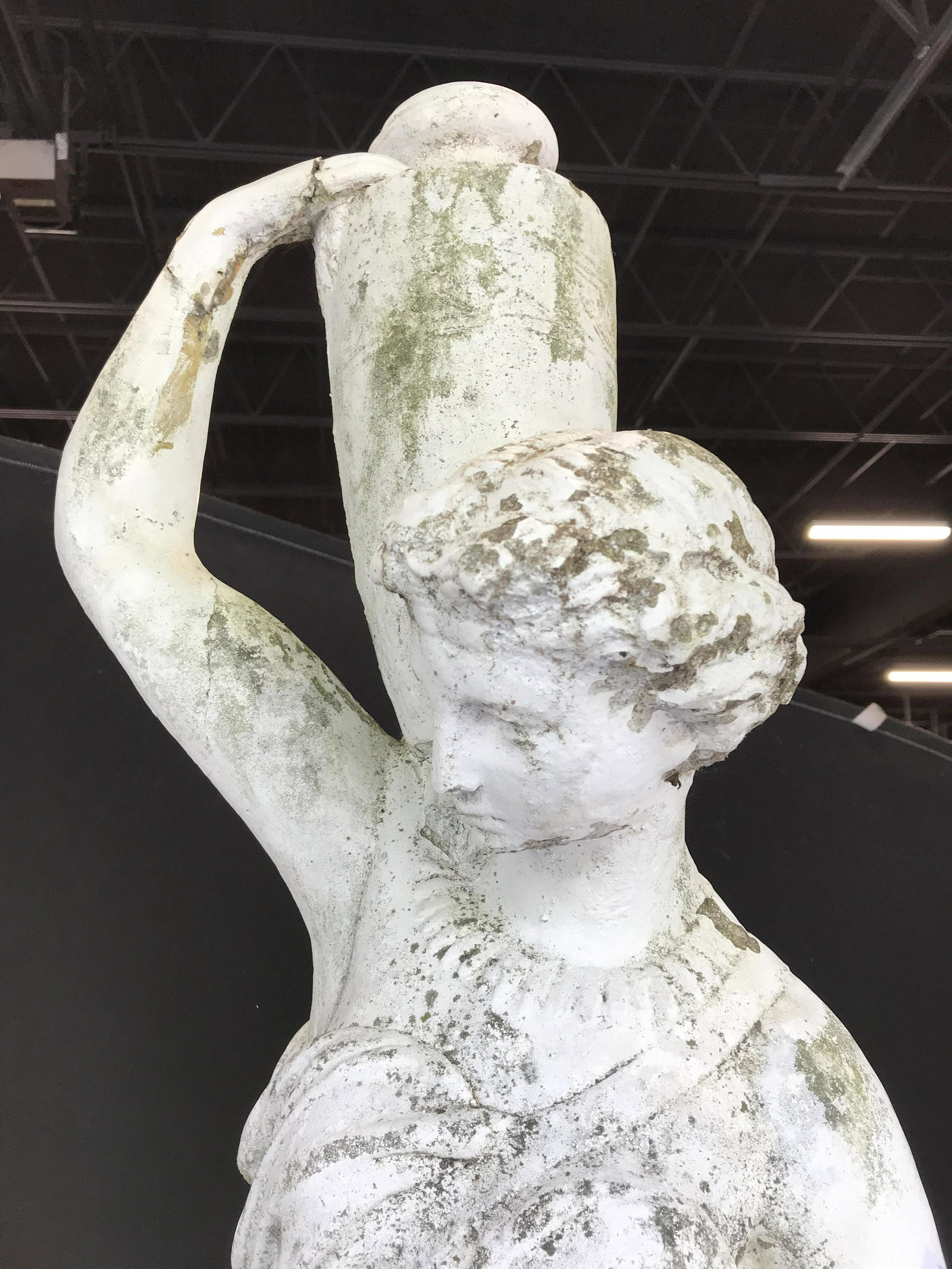 Outdoor White Toned Grecian Sculpture: Piece is white toned & appears to be cement. Piece depicts a female Figural holding a vase. Sculpture is in 2 pieces, base & female figure. Piece measures approximately 66 inches tall 16 inches wide &