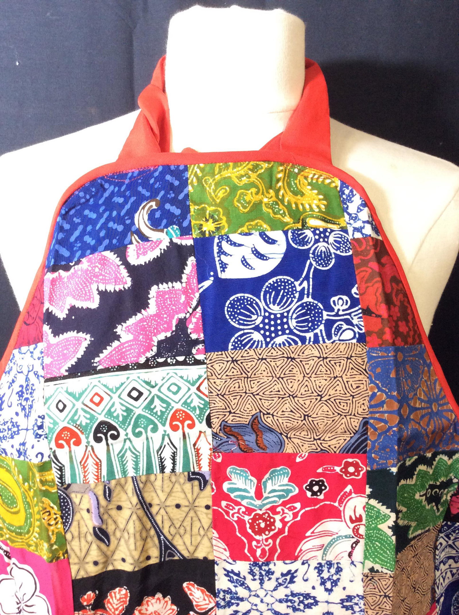 Lot 3 NIP Square Patchwork Batik Aprons: Still in package, colorful cotton batik Cut into patches and sewn together. Tat Backing. Large center pocket. 31 in long. 28 in wide. Straps 19 in. Each side. Bought in Borneo where consignor lived fo