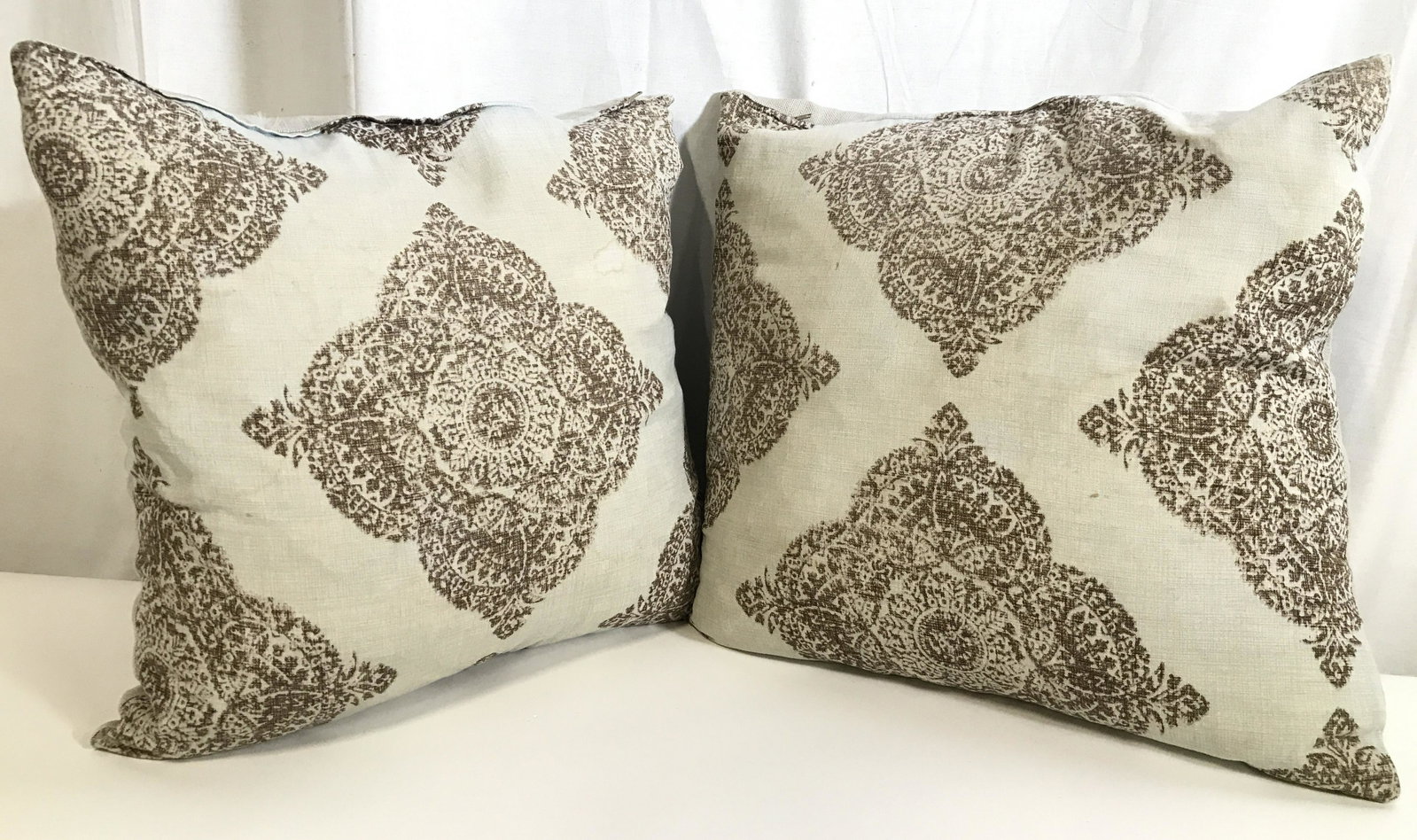 Pair Tan & Chocolate Toned Pillows: Pillows are tan and chocolate toned. Each have intricate pattern detail. Each measures approximately 18 inches square 6 inches deep. Pillows, throw pillows, pair of pillows, home decor, living room de