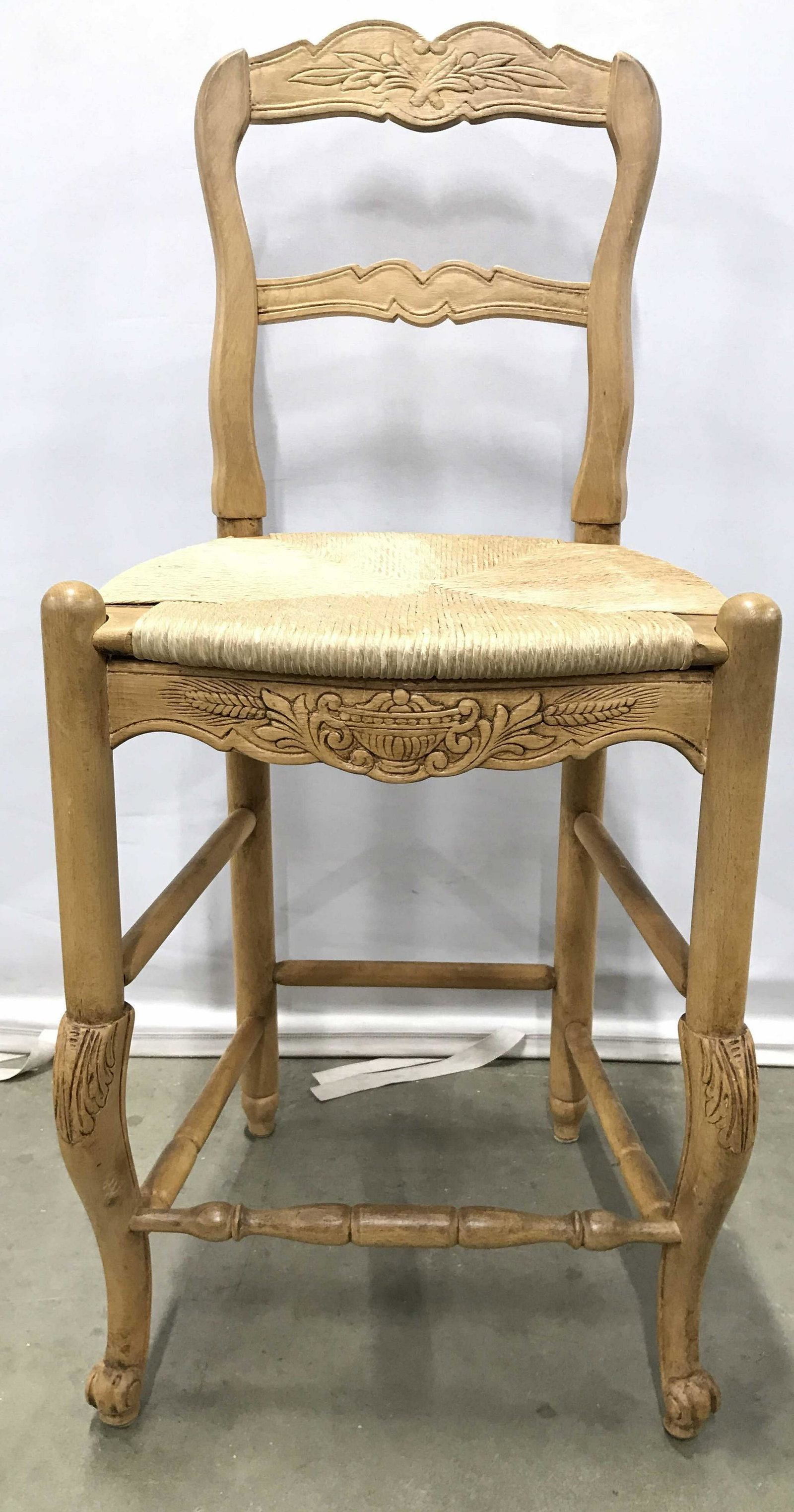 Vintage Carved Wooden Stool W Ladderback: Stool is wooden and tan toned. Piece appears to be vintage. Some elements may be hand carved. Stool has stretchers between legs. Piece has rush seat. Stool also has carved wooden feet. Piece measures 