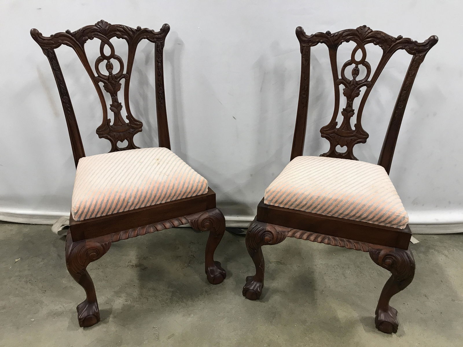Pair Vintage Wooden Children’s Chairs: Pair of carved wood chair. Upholstered cushions are removable, front legs are cabriole with carved detailing, feet resemble clawed hands grasping orbs. Each chair measures approx 26 inches H, 15 inche