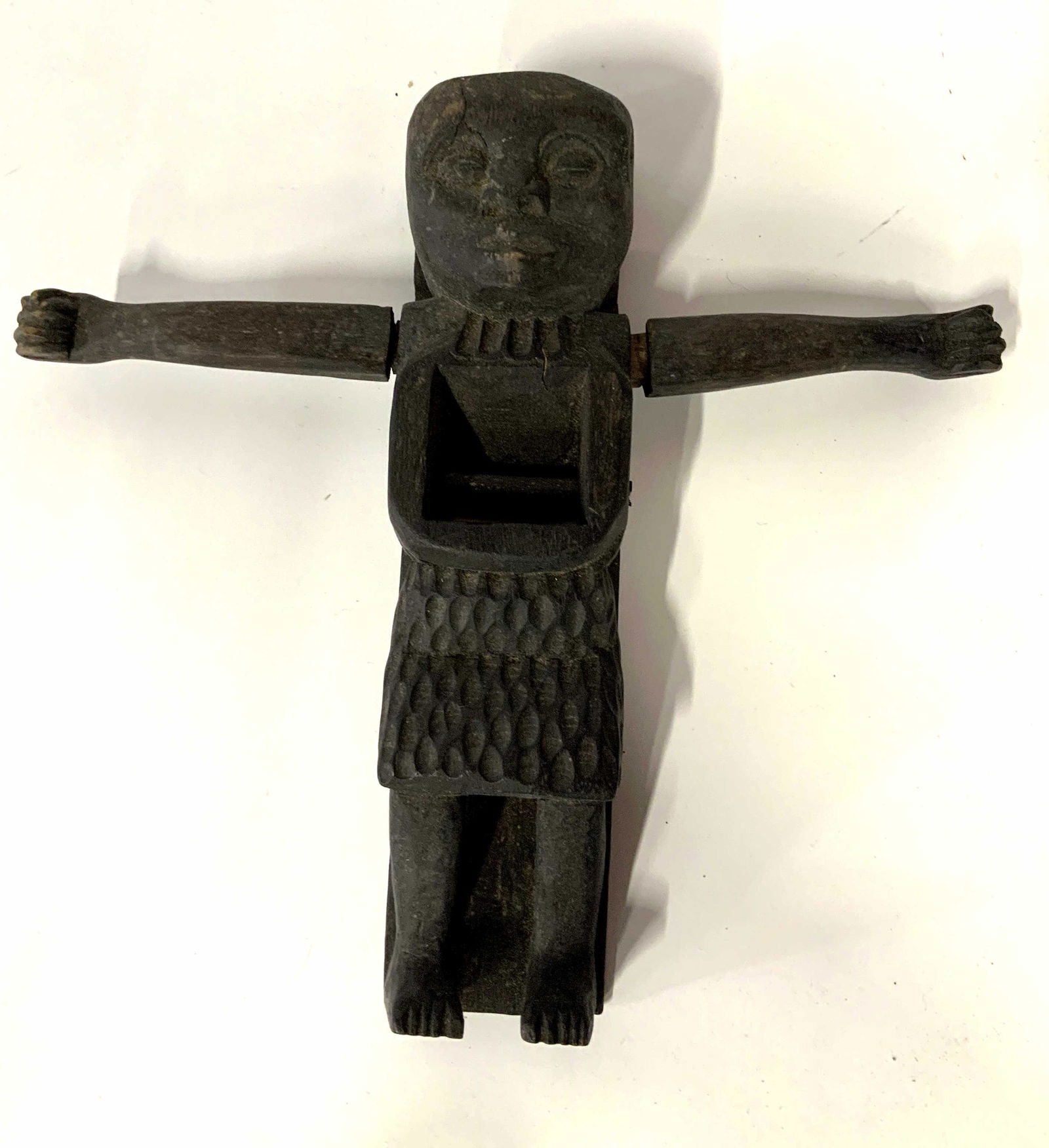 Hand Carved Wood Planer: Hand carved wood planer, possibly Indonesian, no apparent inscriptions or stamps, planer shaped like a man in a skirt, measures 10 1/8 x 10 1/2 inches, arms loose and some cracks in wood but overall i