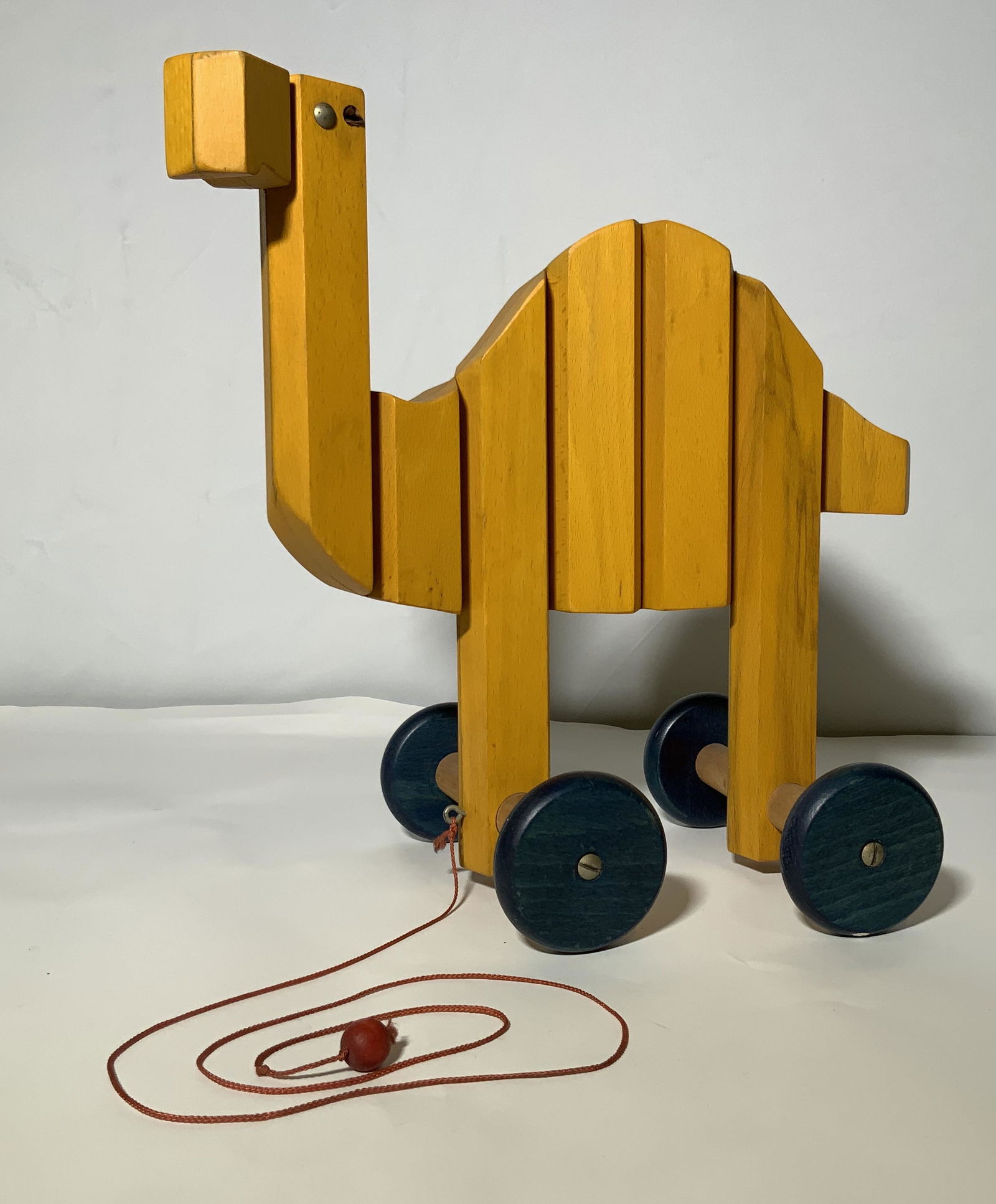Vintage Articulated Painted Wood Pull Toy Camel: A vintage mid century modern painted wood pull toy of a camel, possibly German. The toy is articulated and moves in a slight zig zag when pulled. The toy measures approximately 13.5 inches long by app