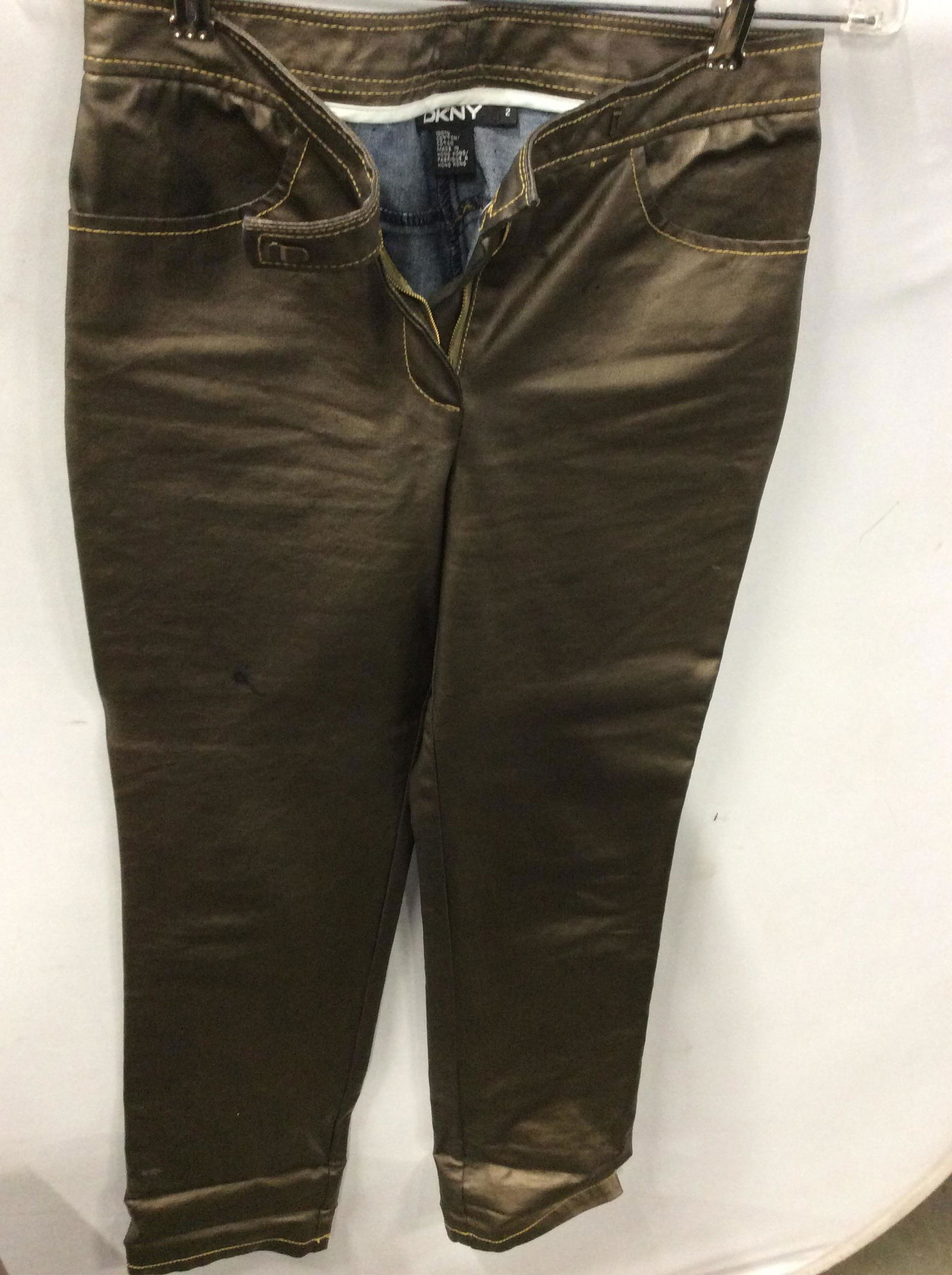 DKNY Bronzed Denim Pants: Size 2, 100% cotton denim with exterior coating that has texture of pleather/ vinyl. Straight leg, long inseam at 32.5 in. Short waisted, hipster. Some blemishes. Very little stretch. Luxury Designer