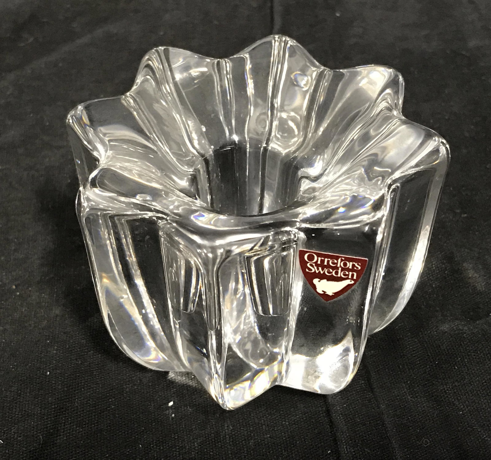 Swedish Crystal Candlestick Holder: Swedish crystal candle stick holder, heavyweight object, holder in the shape of a Star, sticker to side reads ‘Orrefors Sweden’, Mark to underside reads xo, measures 2.5 inches tall and 3.25 inche
