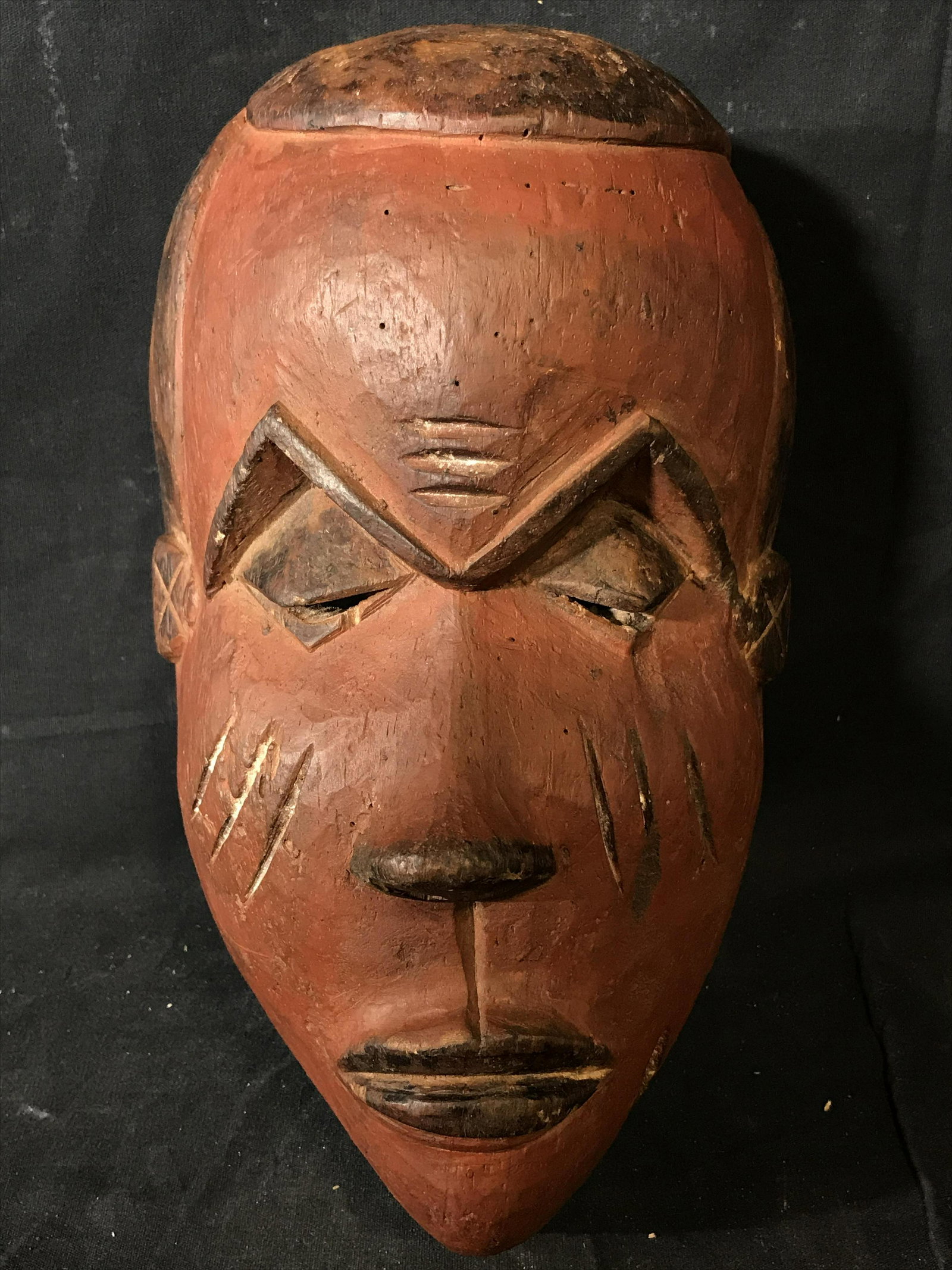 Red Pende Mask: Red Pende Mask, origins found in what was previously known as the Republic of Zaire a section of land that is now apart of the Democratic Republic of the Congo, painted with red black and brown pigmen