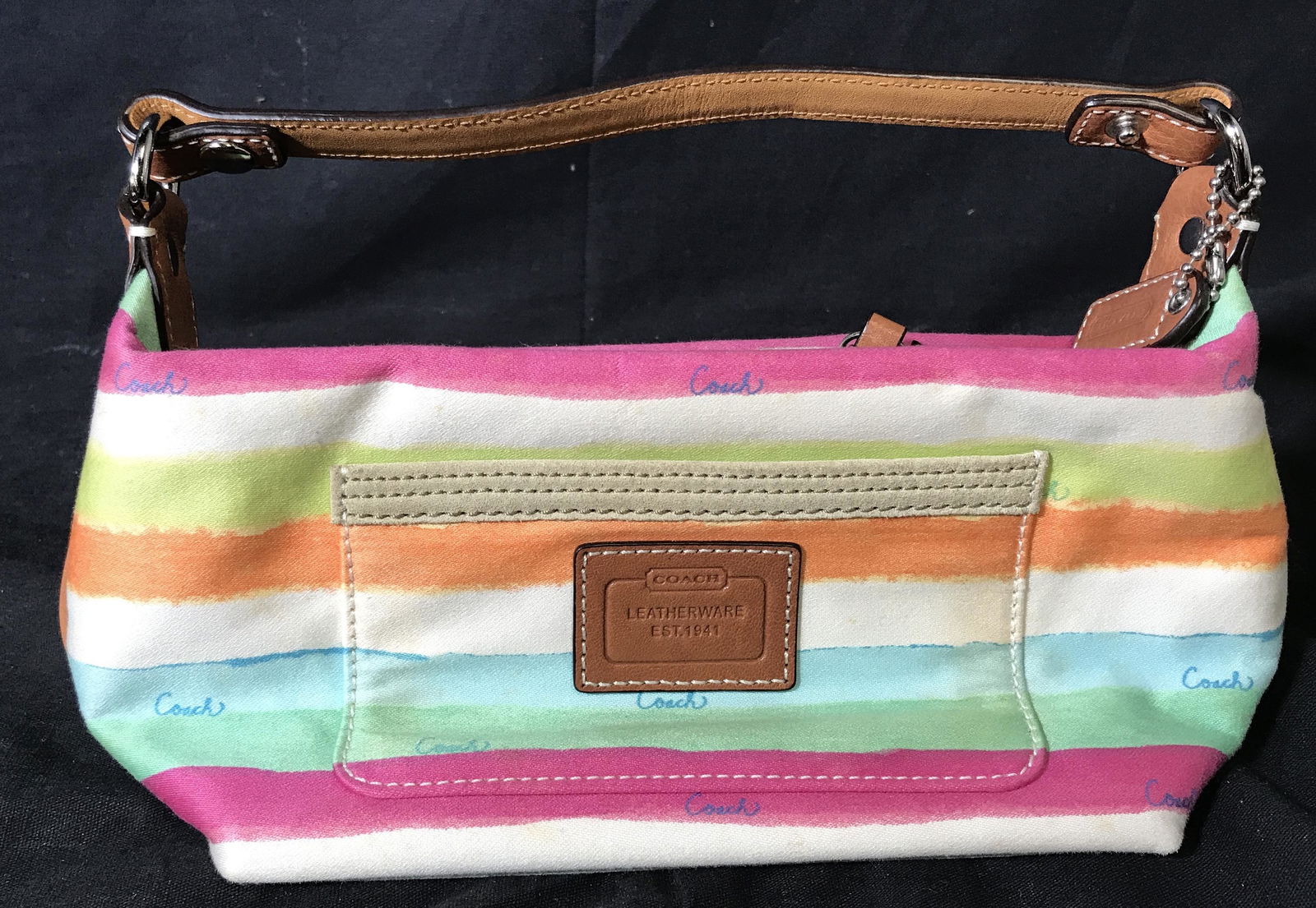 Coach Leatherware Striped Purse: Coach striped purse, purse has a pastel summer striped fabric exterior with blue toned cursive COACH repeating pattern, with brown leather handle and details, interior made of a blue material, bag mea