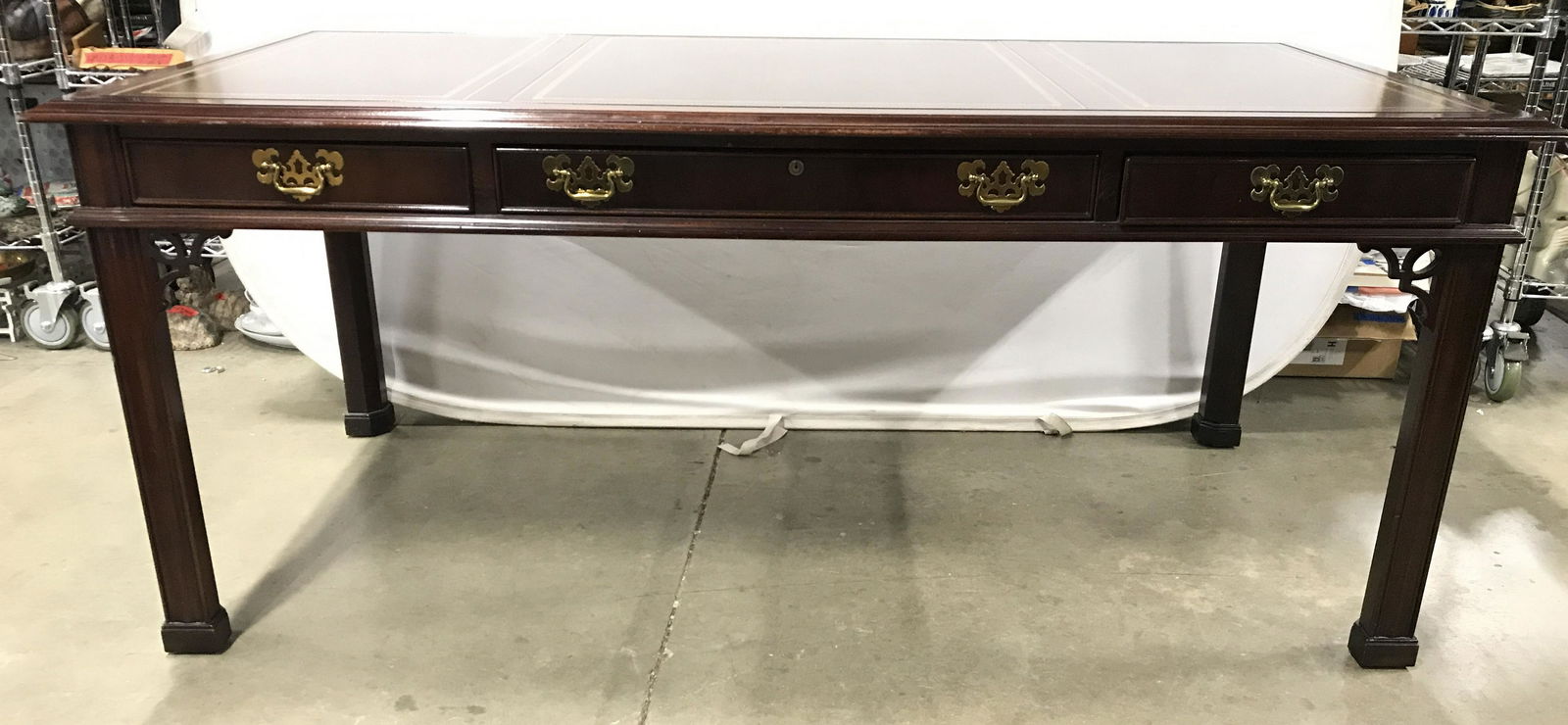 SLIGH VINTAGE Carved Wooden Executive Desk: Interior of drawer is marked SLIGH Furniture. Desk is wooden with carved feet. Piece has 1 large drawer & 2 small drawers. Each drawer has gold toned metal handles. Drawers have hand dovetailing. Tabl