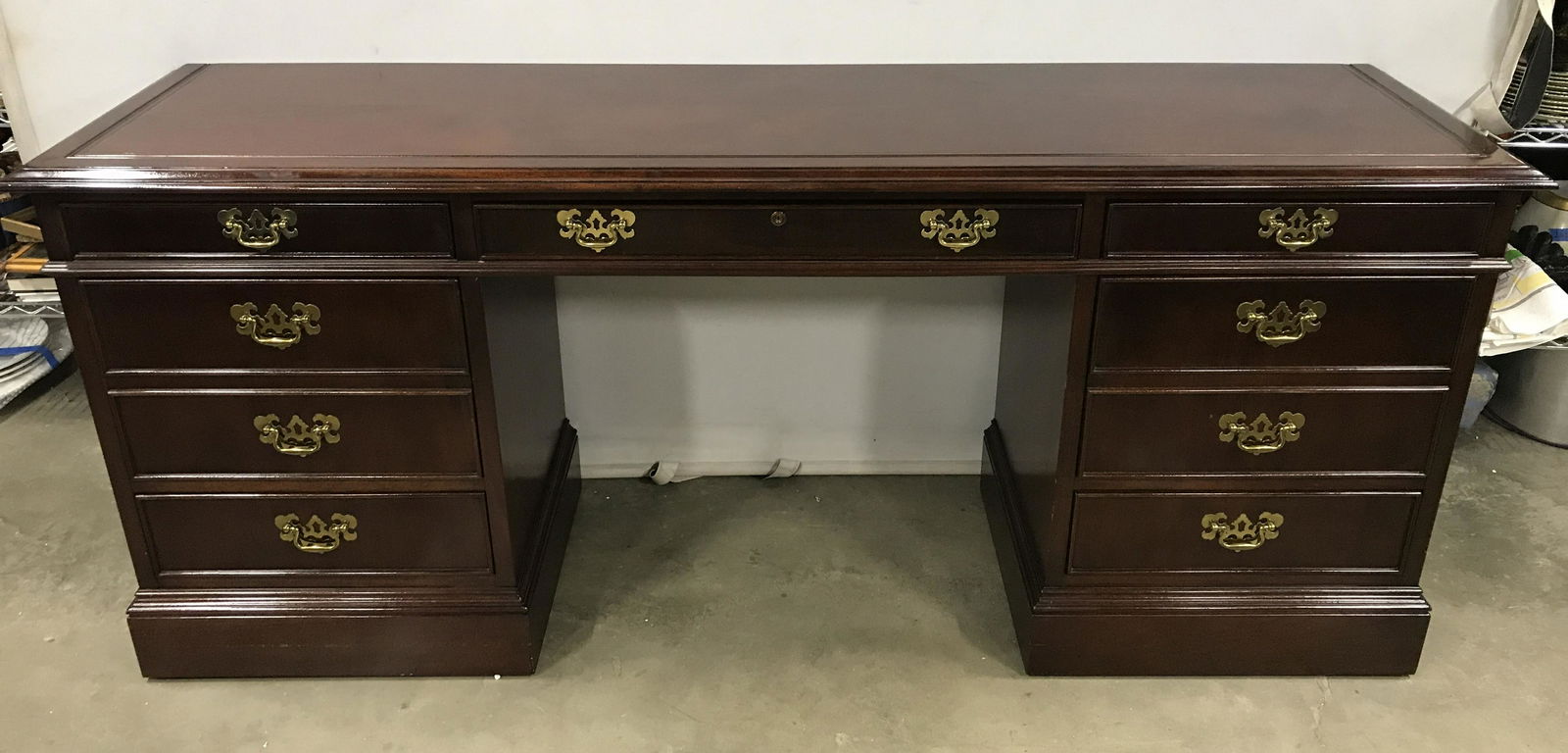 Vintage SLICH Walnut Toned Executive Desk: Interior of drawer is marked SLICH Furniture. Desk is wooden, Piece has 7 drawers, 3 on each side, one in the center. Each drawer has gold toned metal handles. Drawers have hand dovetailing. Center dr