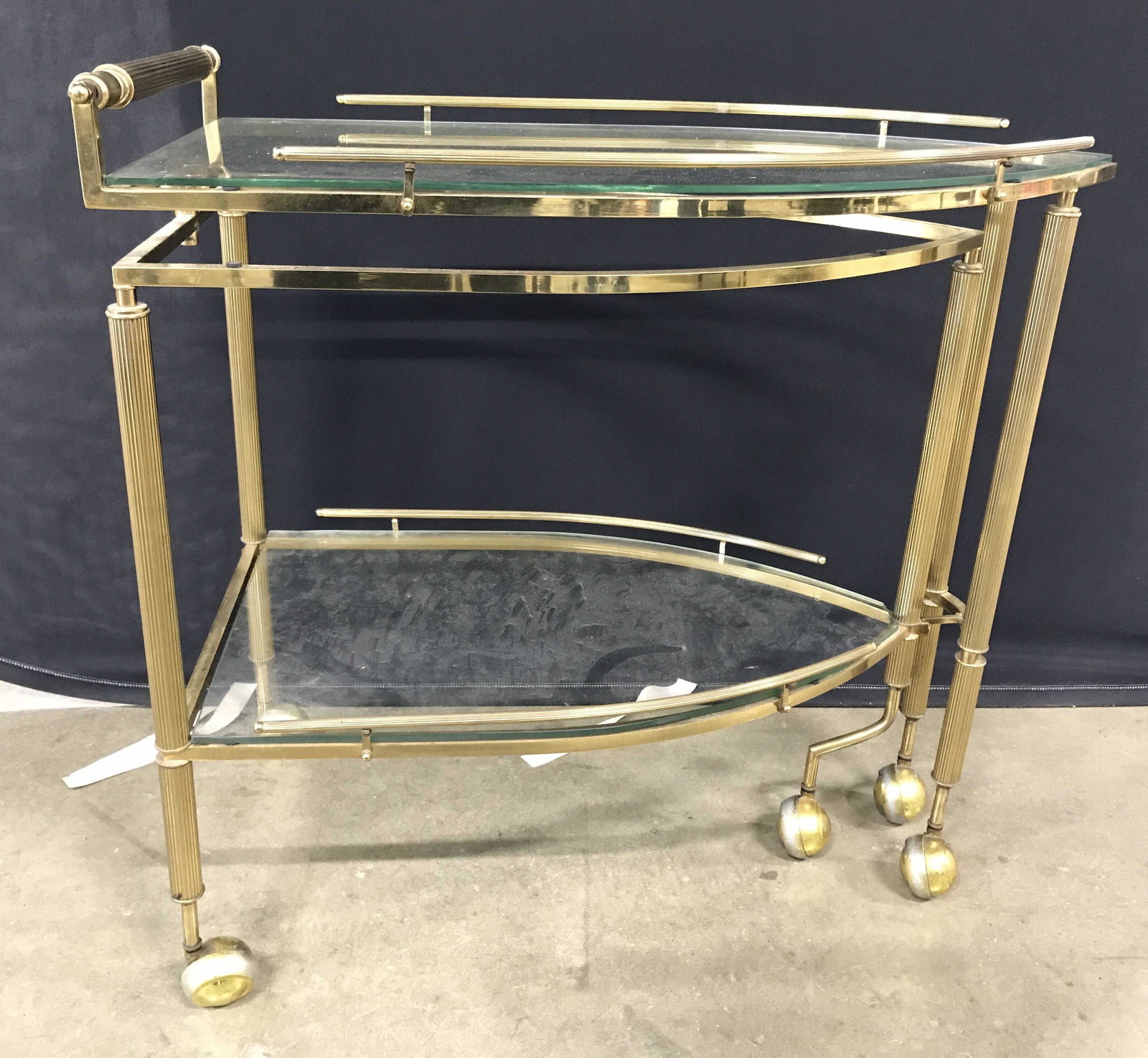Vintage Gold Toned Brass Tea Cart: Tea cart is gold toned and brass. Piece has 2 glass inserts. Each tier has gallery on sides. piece sits on 5 caster. Each measures approximately 31 inches tall 30 inches deep 16 inches wide. Tea cart,