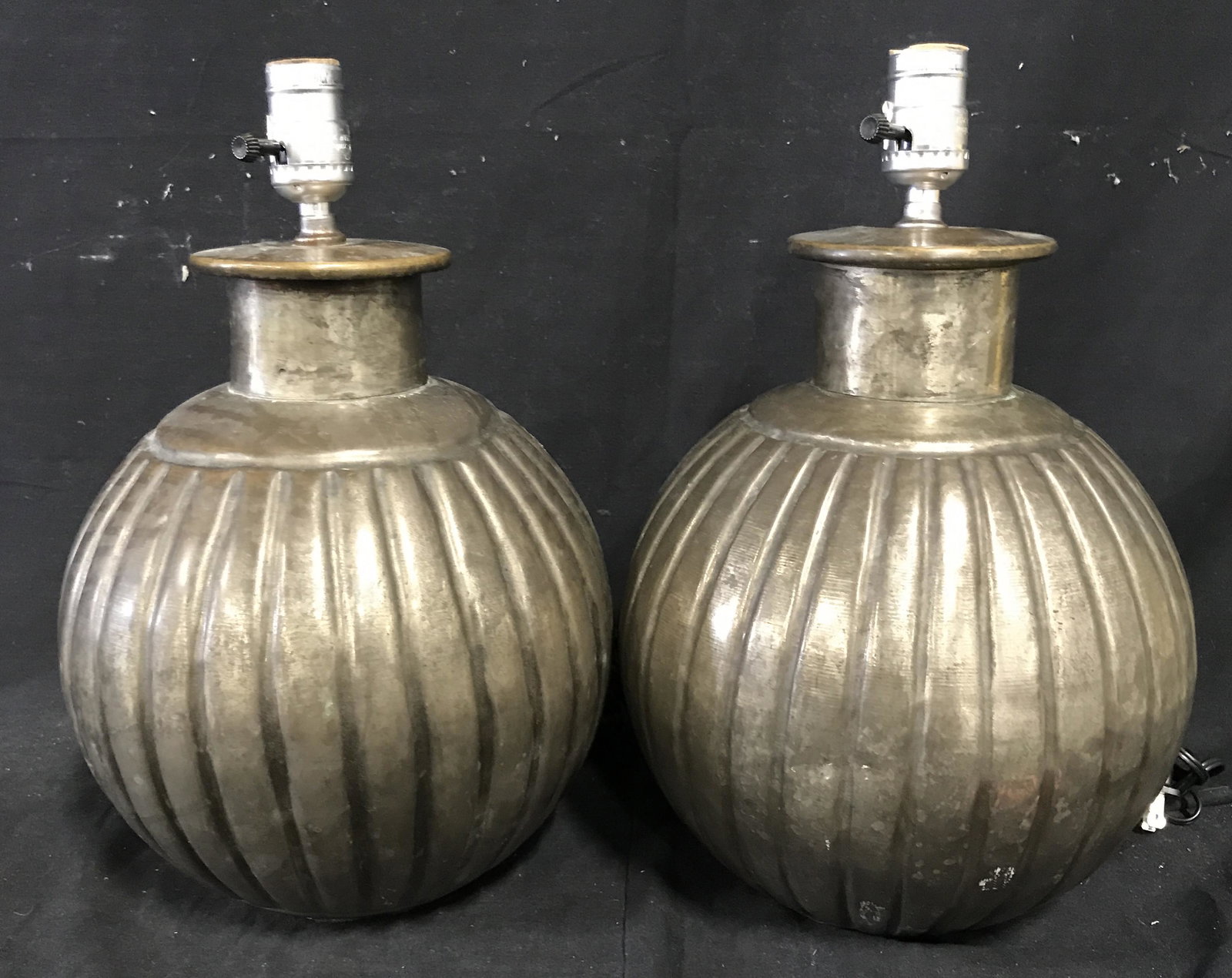 Pair Hollow Metal Ball Lamps: Pair of hollow metal ball lamps, made of a metal with hollow interior, some wear to surface, some dents to surface as well, silver toned metal accents to the top, neither some with lamp shades, both m