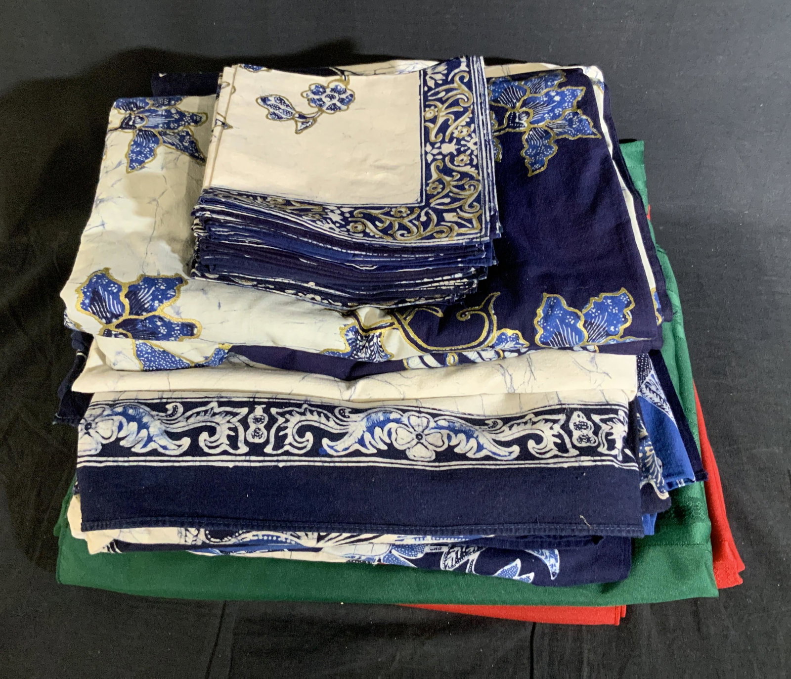 Lot 30 Indonesian Batik Tablecloths and Napkins: Lot 30 Indonesian Batik Tablecloths and Napkins, no apparent labels or inscriptions, 22 cloth napkins, napkins measure 14 3/8 x 13 3/8 inches, blue, white, and gold tablecloth measures 152 x 57 inches