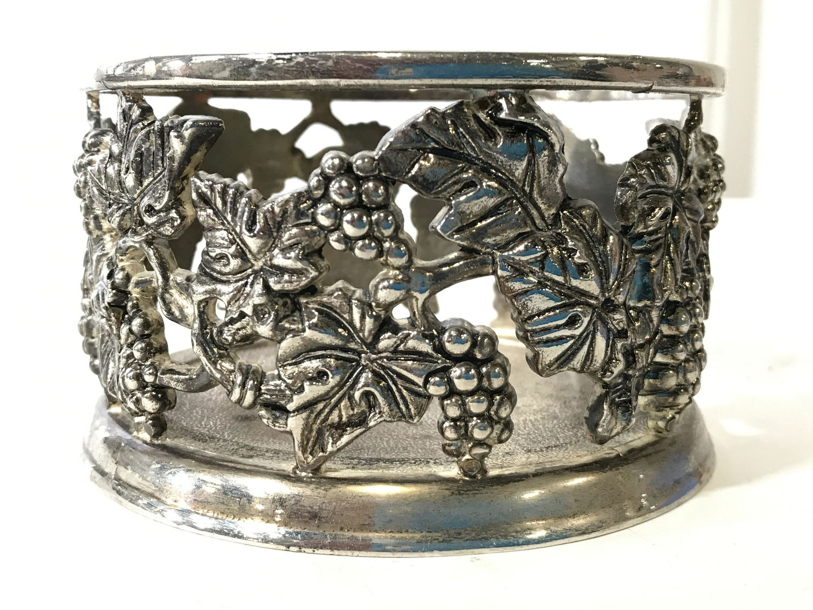 Pair Silver Toned Pewter Wine Coasters: Coasters are silver toned and pewter. Each have grape leaf and vine detail. Each piece measures approximately 3 inches tall 5.5 inches wide, 4.5 inches deep. Wine coasters, wine bottle coaster, Pewter