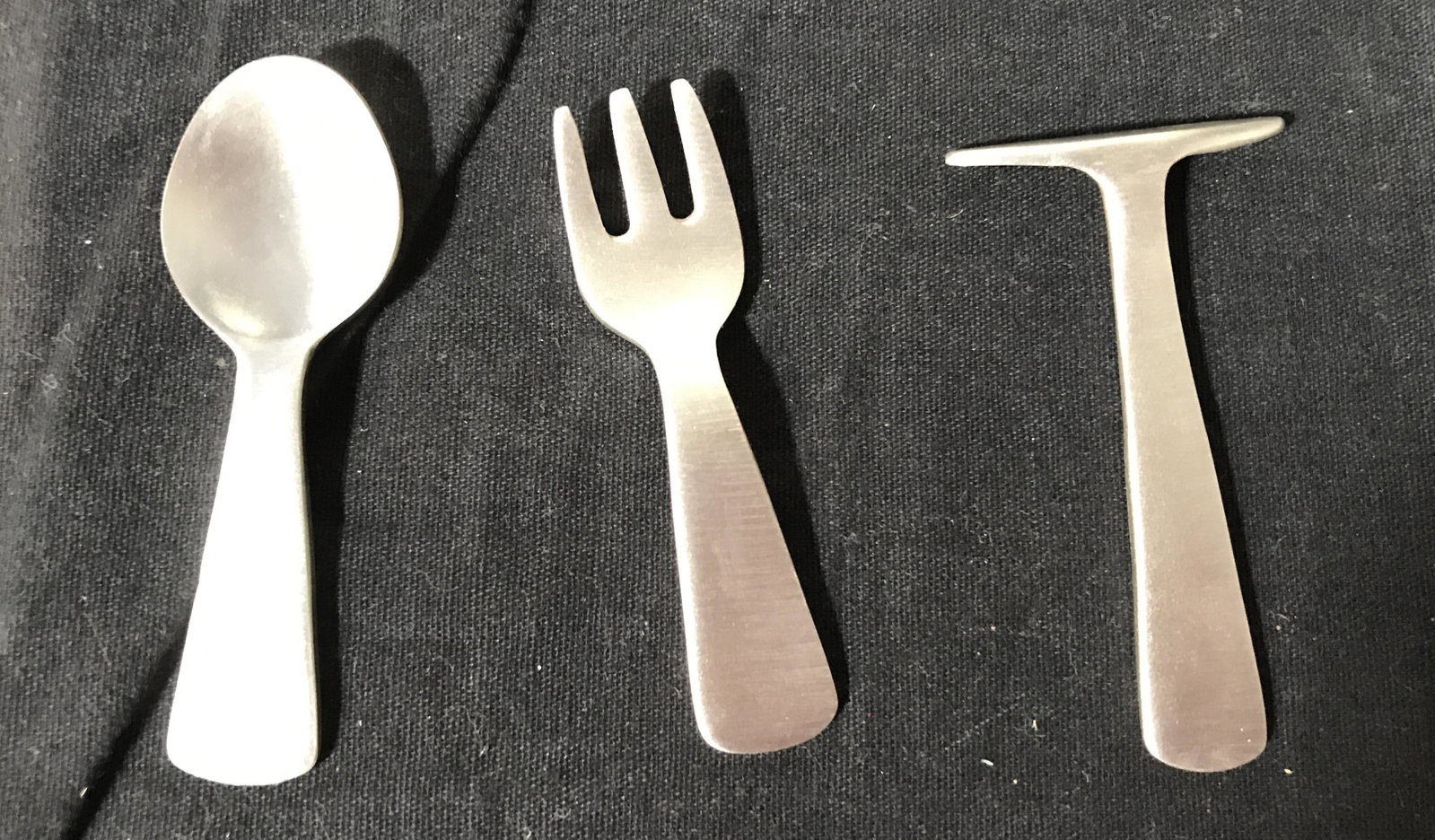 WOODBURY PEWTERERS Pewter Cutlery Set: Set of three pewter utensils. Include a Spoon, fork, and scraper. Includes plastic case and care instructions. Largest piece measures approx 3 inches long, and 1.5 inches W. The underside of each read