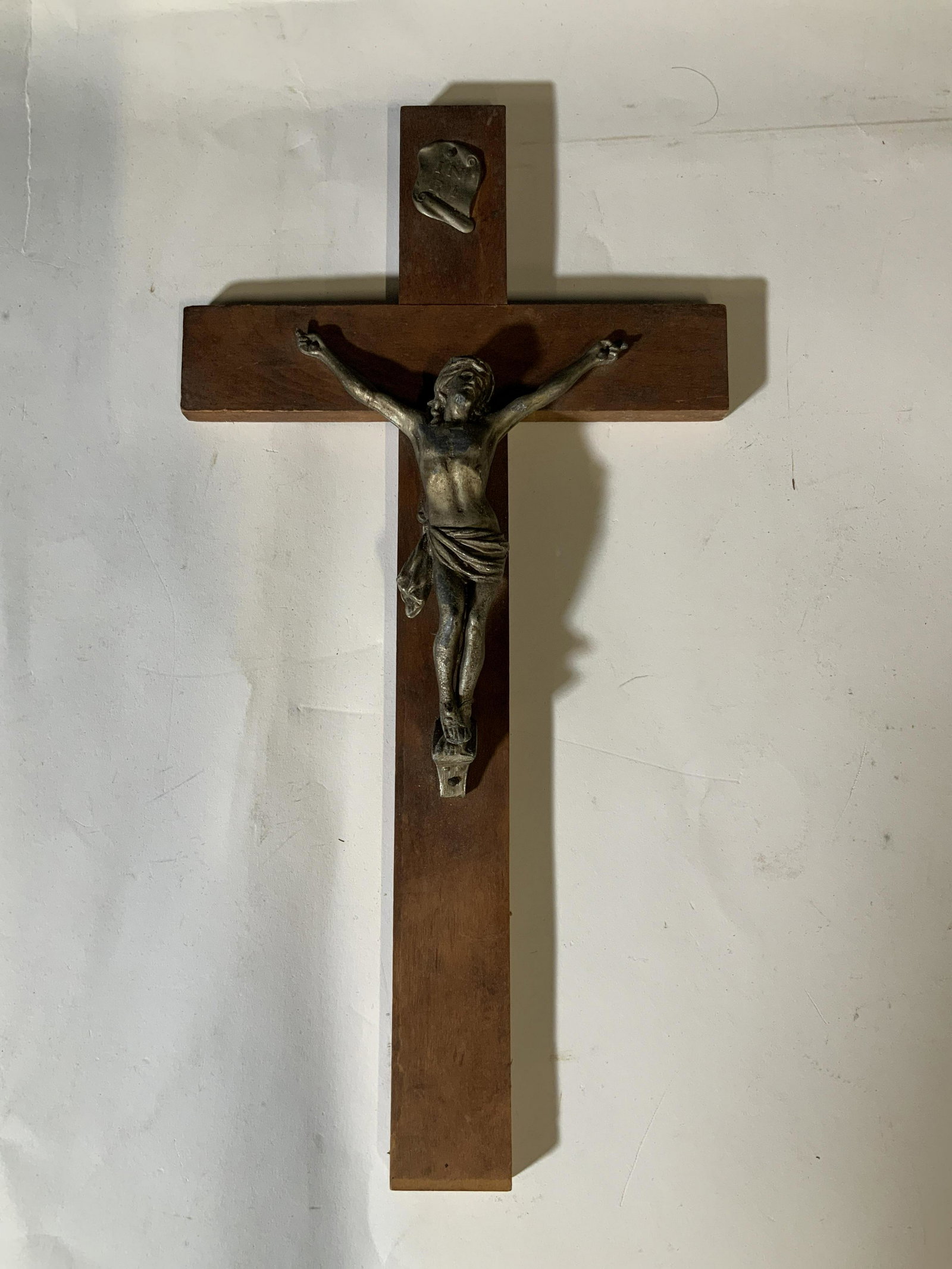 Jesus Christ Wooden Cross, Wall Decor: Jesus Christ depicted on the cross, hanging wall decor. Lettering above Jesus reads: ‘Inri’, which is thought to refer to ‘Iesus Nazarenus Rex Iudaeorum.’ 15in height, 8in across. Hanging wood