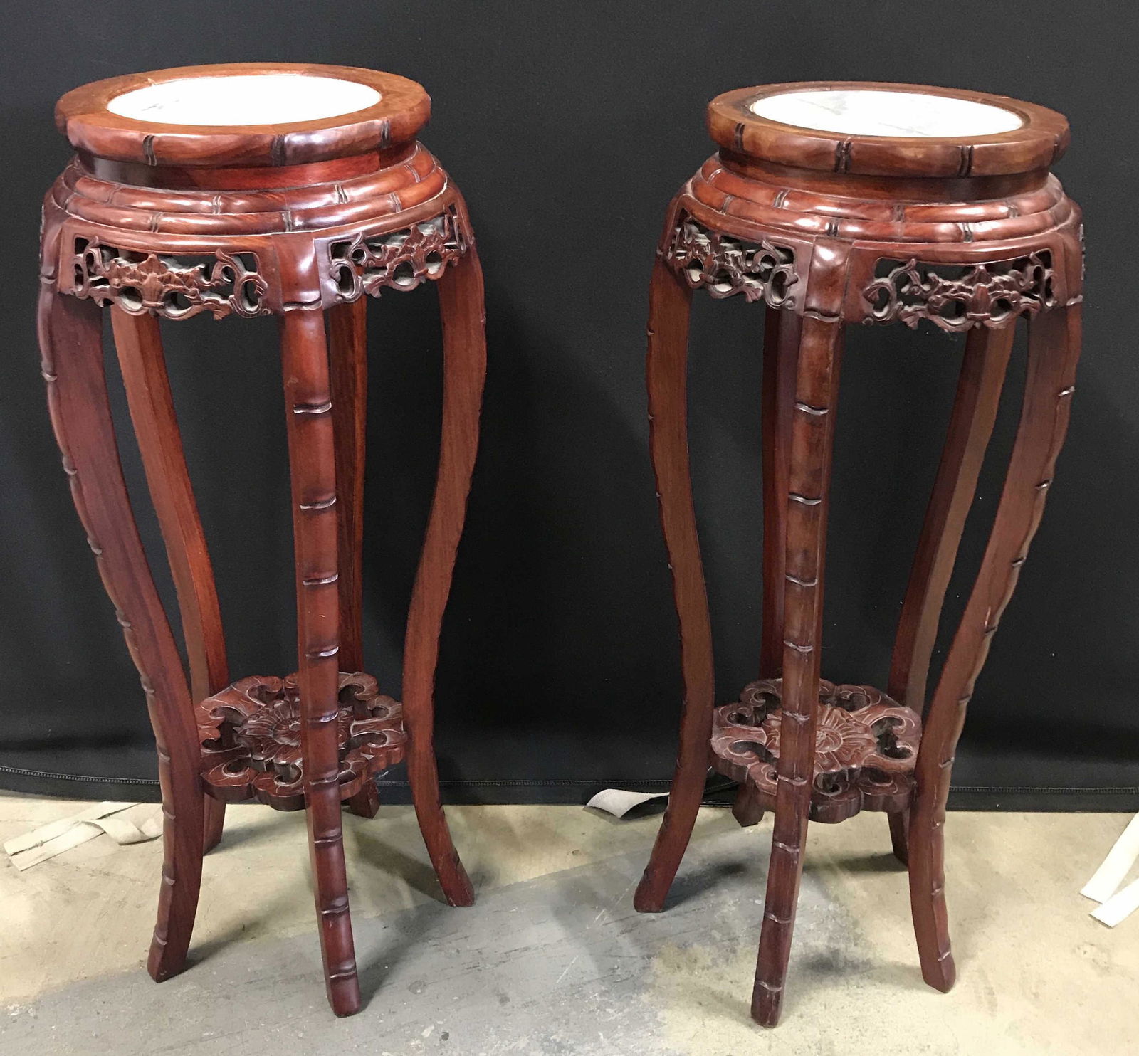 Pair Carved Wood Marble Topped Side Tables: Pair vintage tables, possibly antique. Carved wood frames with marble tops. Each measures approx 32 inches H, and 12 inches in diameter. Wear is consistent with age and use. Orientalia, Orientalism, a