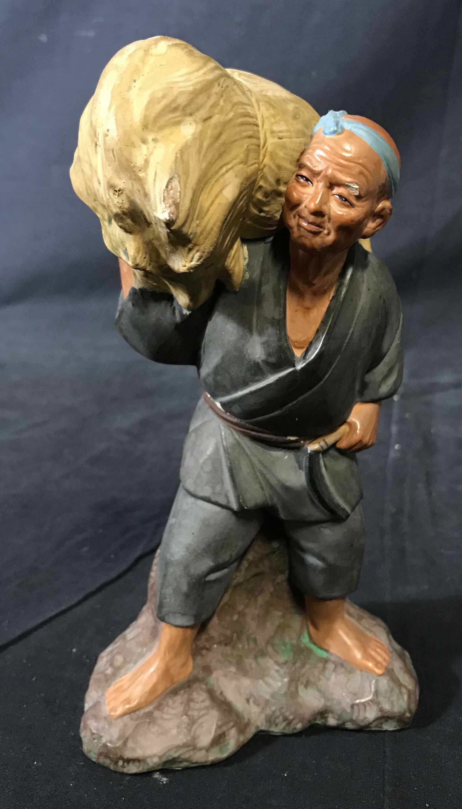 Vintage Ceramic Farmer Figural: Vintage Ceramic sculpture, the piece is hand painted. Sculpture depicts a man carrying a bail of hay. Measures approx 8.25 inches H, and 2.5 inches W. Wear is consistent with age, some cracking is pre