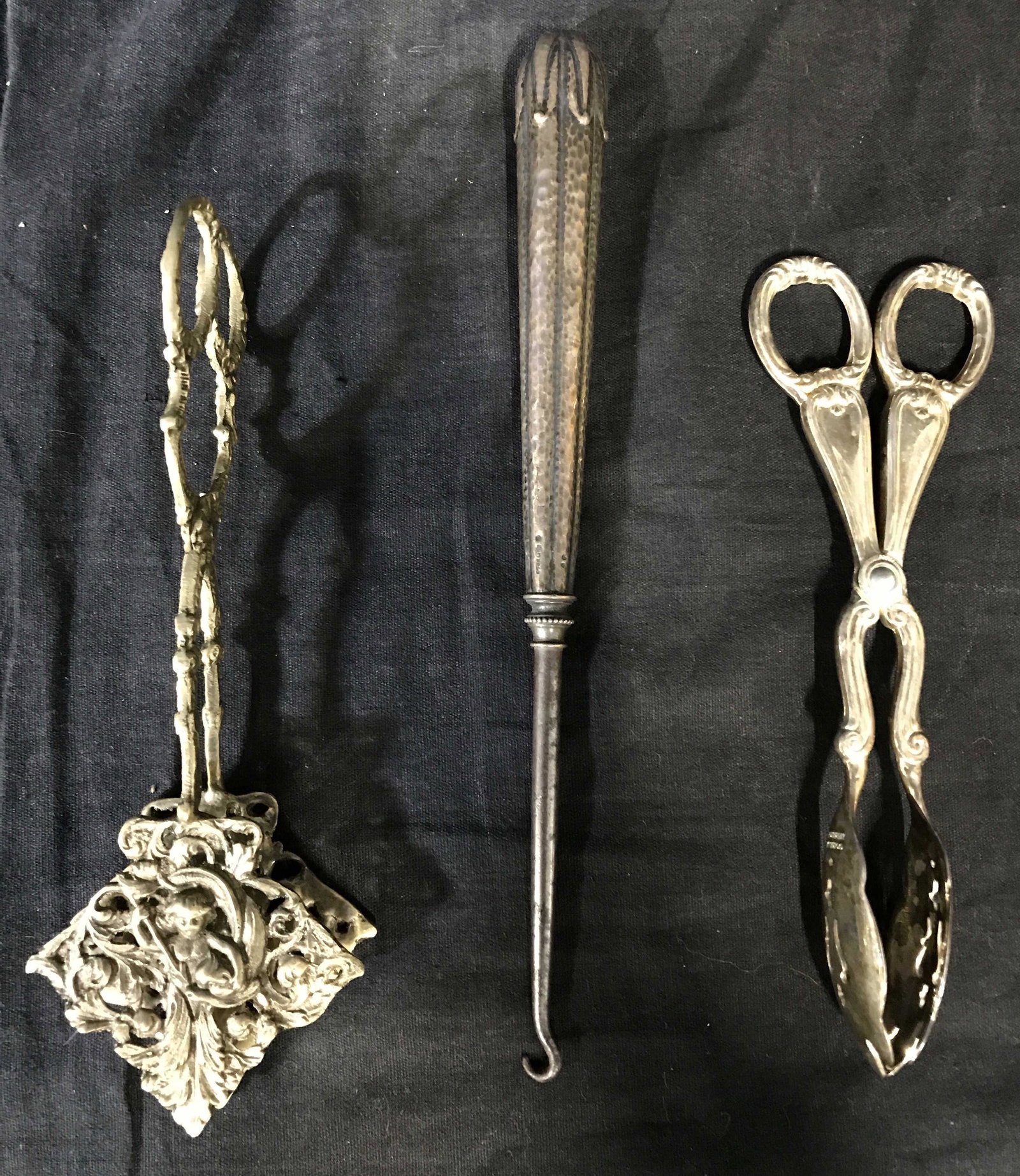 Lot 3 Silver Plated Accessories: Lot of three silver plated accessories. Includes two tongs and a boot hook. The tongs Bear GORHAM hallmarks. The largest piece measures approx 7.5 inches Long and 2.75 inches W. The pieces feature var