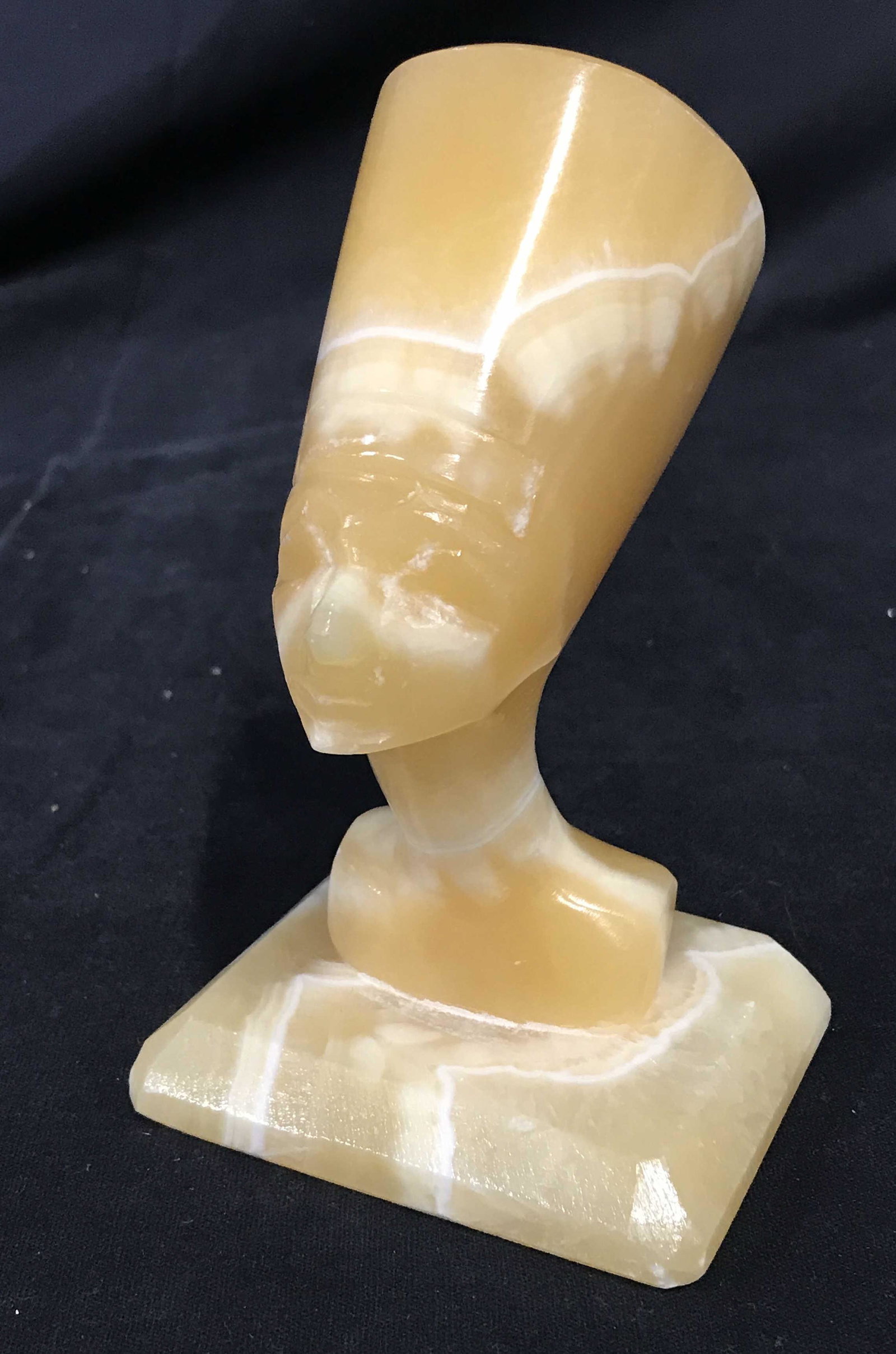 Carved Stone Egyptian Style Bust: Carved stone bust, desk size. Depicts what appears to be a female figure wearing a Modius. Measures approx 5.25 inches H, and 3.25 inches W. Wear is consistent with age. Ancient Egyptian, desktop acce
