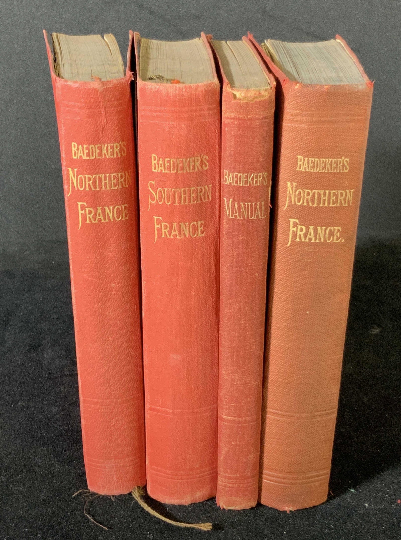 Antique Set BAEDEKER’S GUIDE BOOKS, 4: Antique set of 4 guide books written by Karl Baedeker. Bound in red with gold-colored lettering. Books contain maps of the regions. 1991 Article from New York Times about Baedeker within the back page