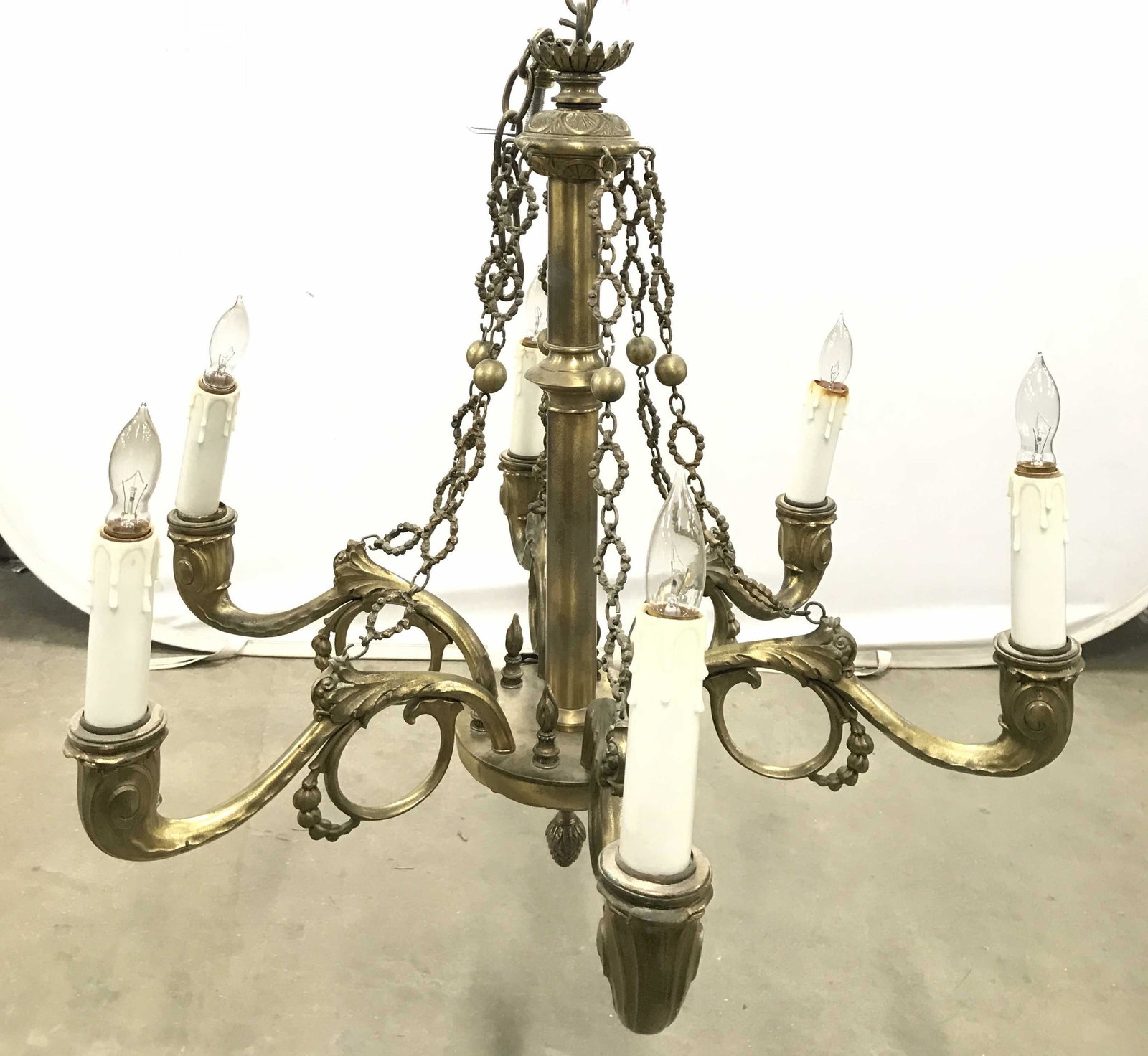 Vintage Gold Toned Brass Ornate 6 Arm Chandelier: Chandelier is gold toned and brass. Piece has 6 ornately detailed S scroll style arms with candlesticks style bulb sockets. Chandelier is vintage possibly antique. Piece has finial like structure at b