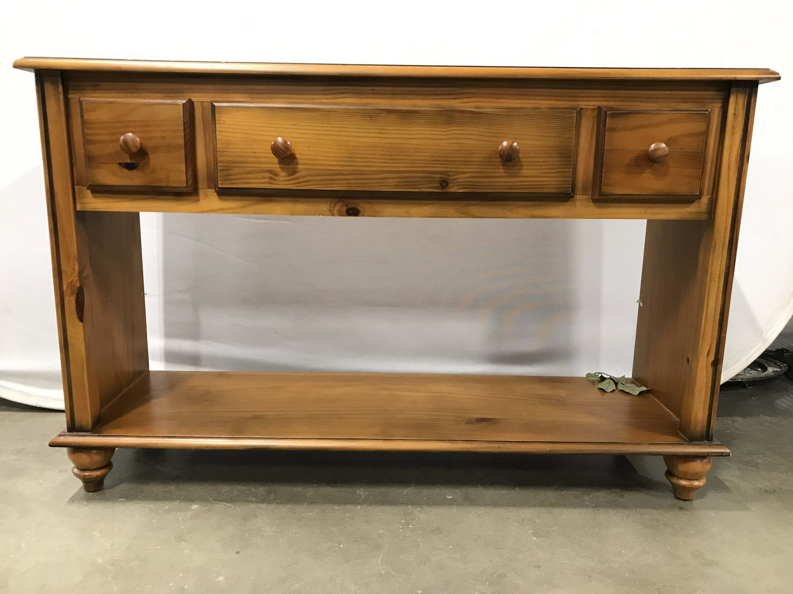 Vintage Footed Wooden Console Table: Console table is wooden. Piece is tan toned. Contains 1 Large drawer & 2 small drawers. Each have knob style wooden handles. Console table has carved wooden feet. Table measures approximately 46 inche