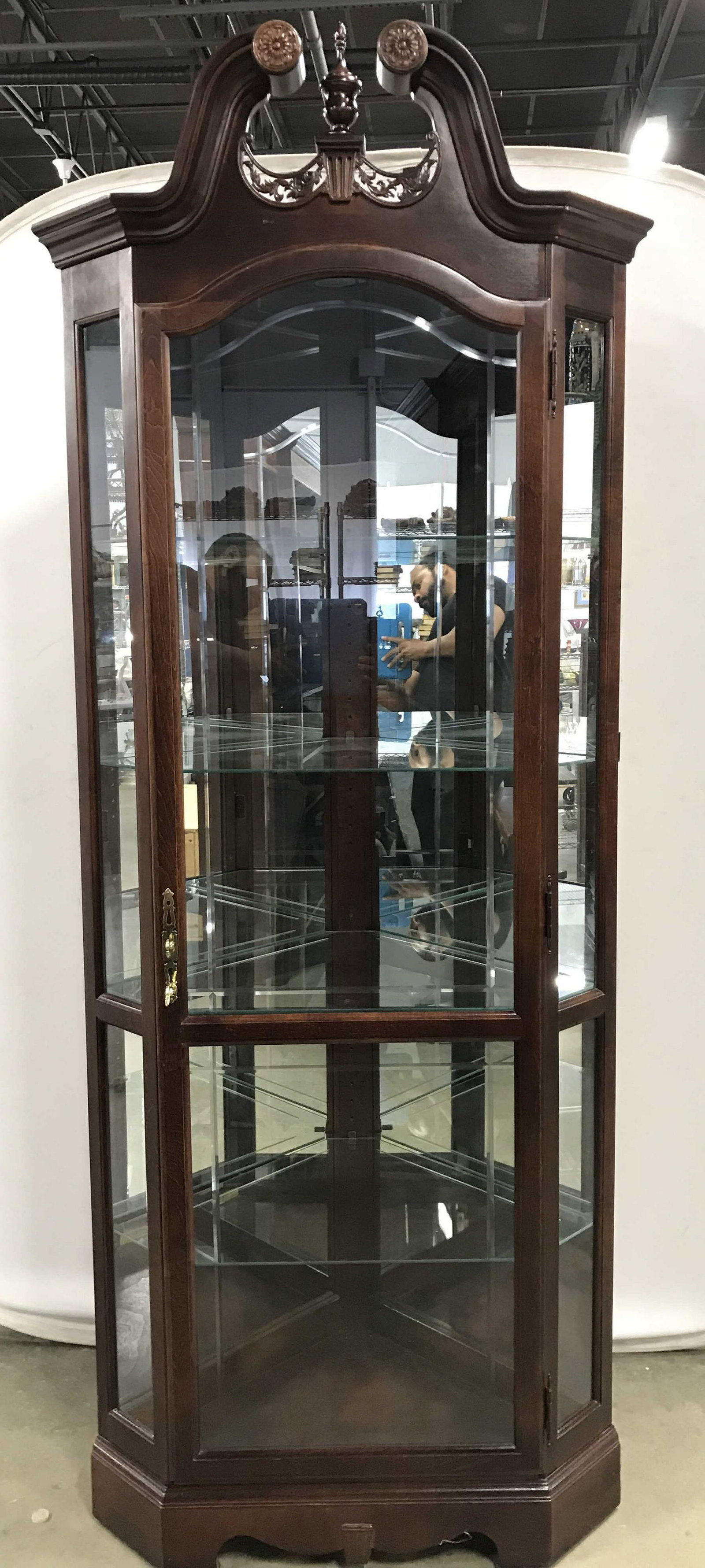 HOWARD MILLER Wooden Glass Shelf Display Case: reverside has tag which reads HOWARD MILLER Display case is wooden. Piece is possibly vintage. Piece is mahogany toned possibly genuine mahogany. Top of piece has intricately carved wooden Floral leaf