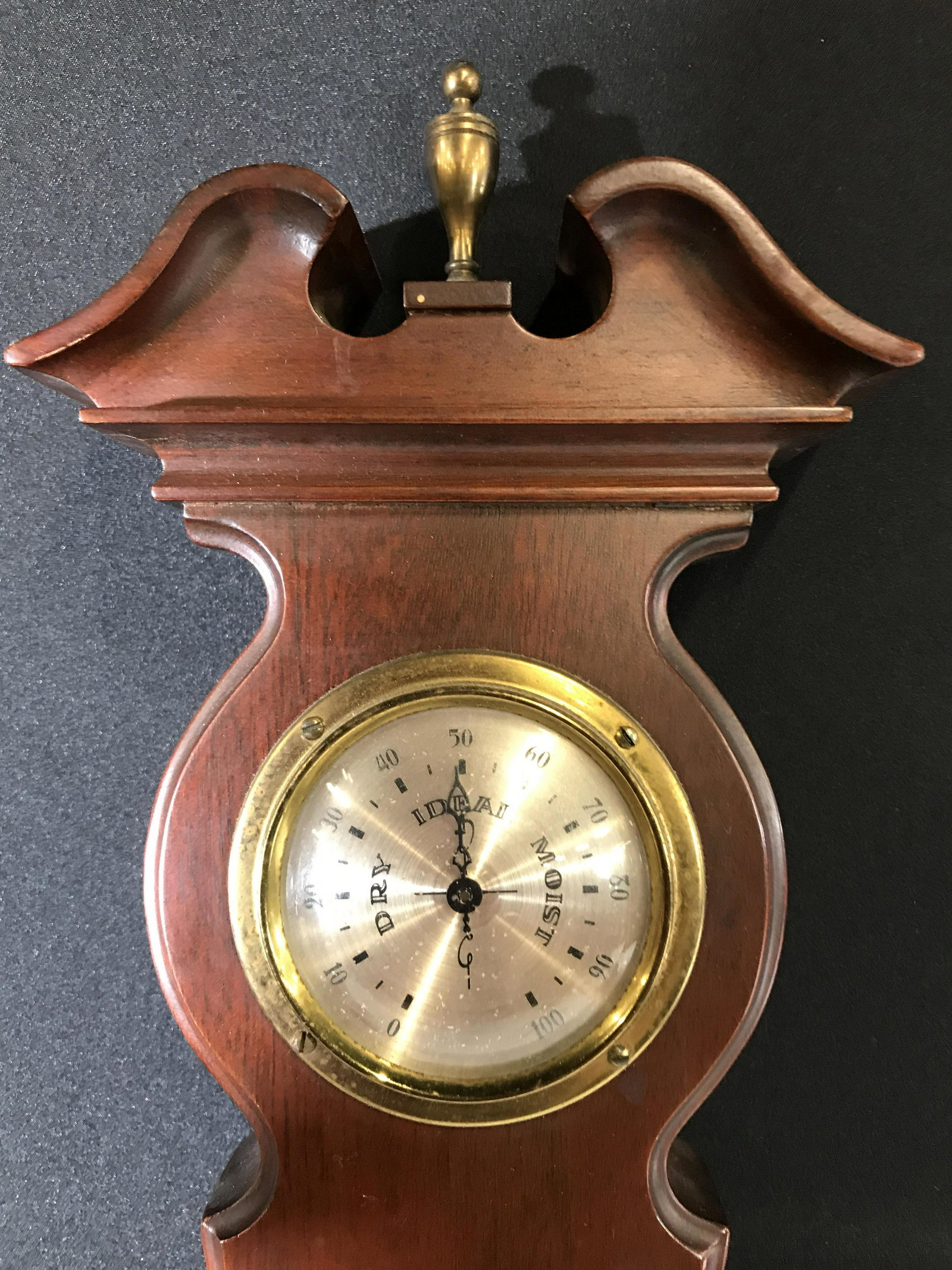 Vintage Barometer Weather Instrument: Vintage weather instrument. Wood frame houses a barometer, thermometer, clock, and hygrometer. Measures approx 32 inches H, and 9 inches W. Wear is consistent with age and use. Weather instrument, clo