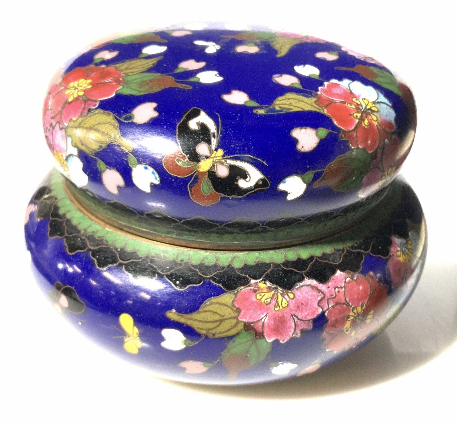 Vintage Asian Floral Cloisonné Vessel: Decorative cobalt blue enamel vessel designed with flowers and butterflies. Hand painted Asian inspired artwork features gilt line work (worn due to age and exposure). Interior & underside hunter gree