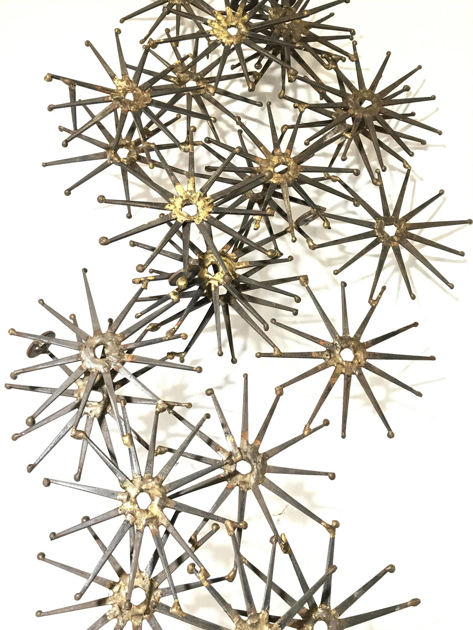 Vintage Metal Wall Mount Star Burst Sculpture: Sculpture is metal. Piece has multiple conjoined spoked structures. Sculpture, metal sculpture, wall decor, wall accessories, wall art, wall sculpture, industrial sculpture, wall mount sculpture. Piec