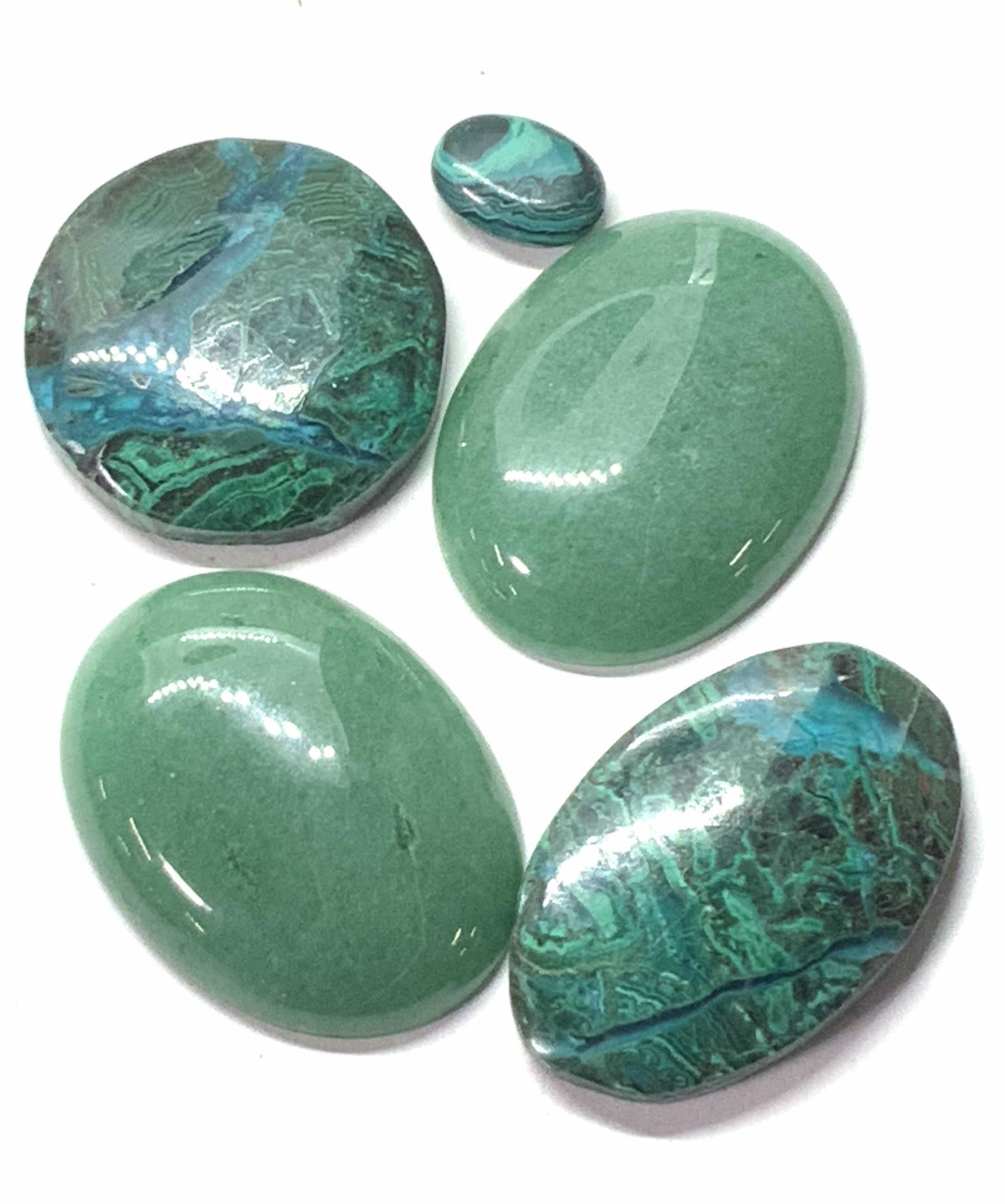 Lot 5 Oval Jadeite Mixed Gemstones: 5 polished gemstones, two possibly jadeite. Two Chrysocolla with malachite and a 14 x 10 mm malachite. Can be set in broaches or pendant necklaces. Largest approx. 1.5 in. X 1.5 in. Gemstones, malachi