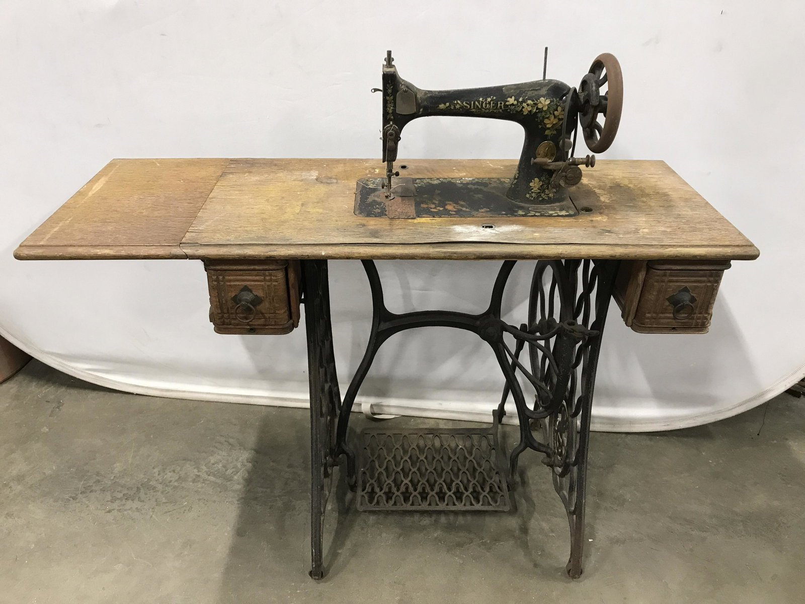 Antique SINGER Sewing Machine Table: Antique sewing table, by SINGER. Tabletop and sewing machine cover are crafted from carved wood, door leaf allows for extension. Frame and pedal are crafted from cast iron, drawer pulls and leaf suppo