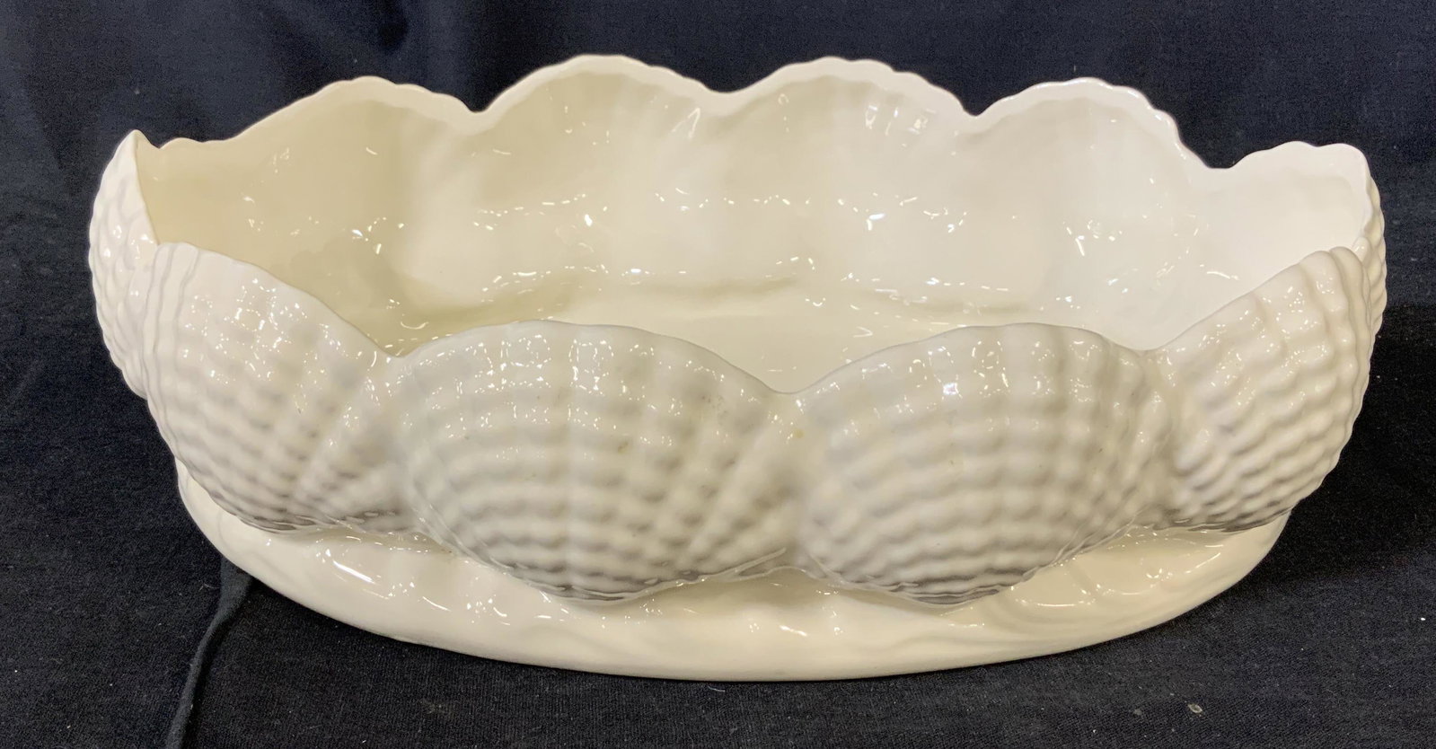 White Ceramic Dish with Shell Design: Ceramic dish with shell design. white toned, embossed scallop / shell design, centerpiece with ridged base, no apparent inscriptions or stamps, Measures 12 1/4 inches x 8 5/8 inches at widest points, 